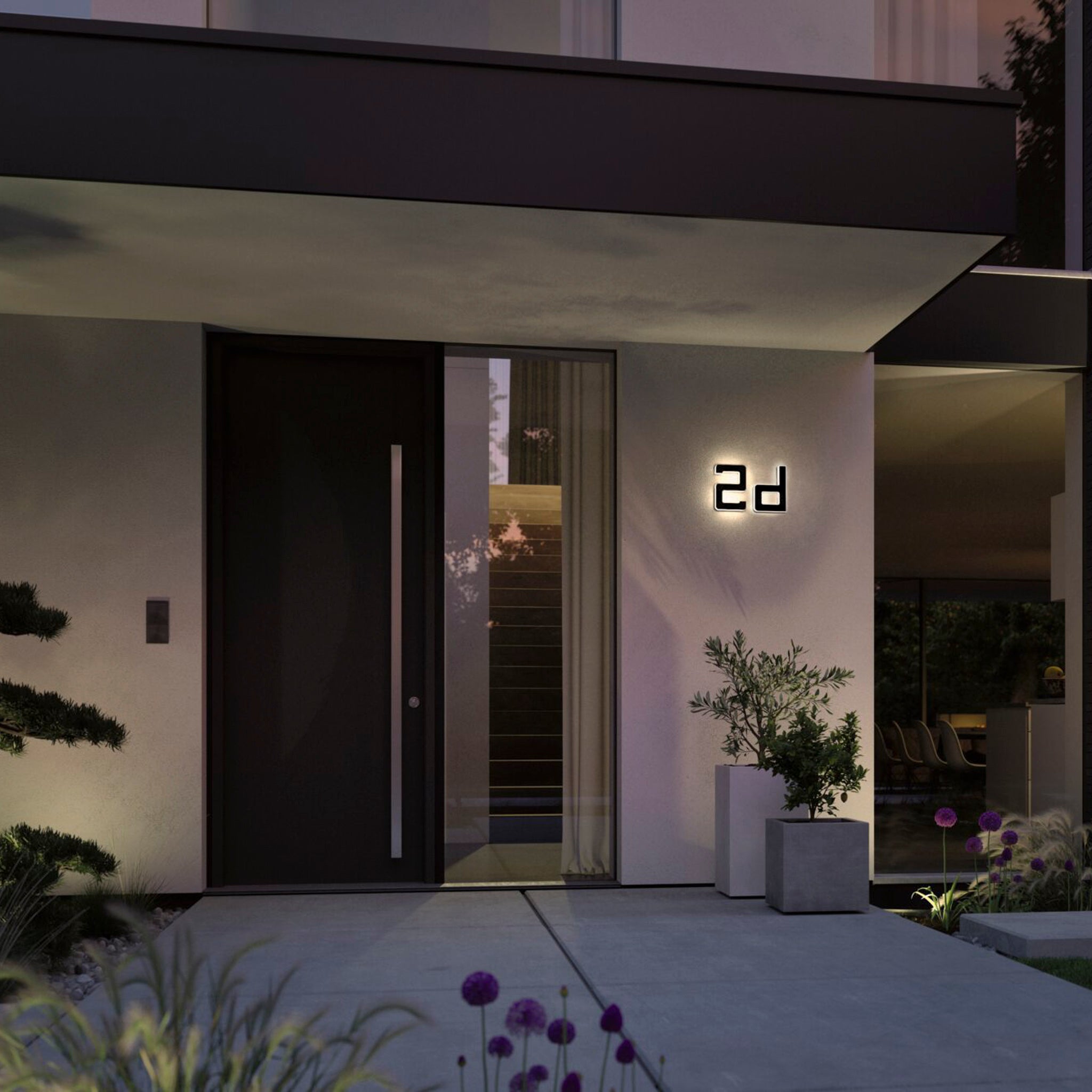 A modern house entrance showcases a tall dark door, large windows, and the Paulmann Outdoor Solar House Letter D LED 0.2W with a replaceable battery in black, illuminating the "D" on the wall.