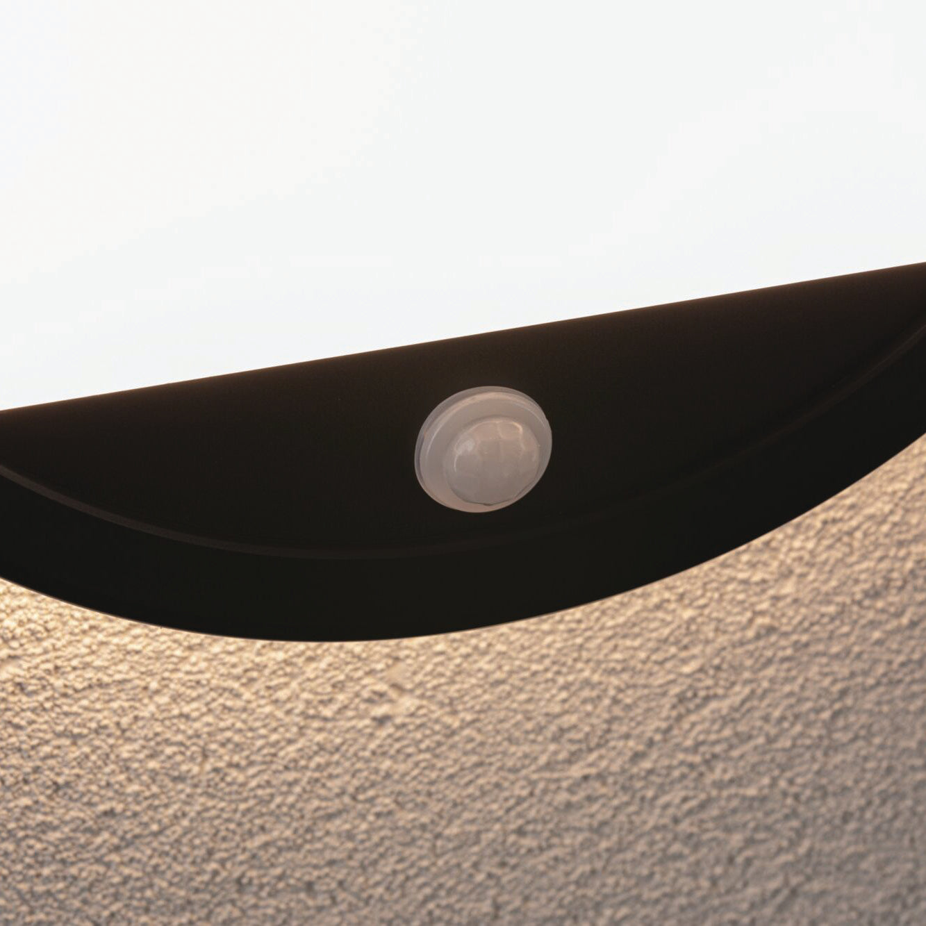 Close-up of the Paulmann - Outdoor Lamina Insect Friendly 16W LED Backlit Round Tunable Wall Light with Motion Detection in Black, seamlessly integrated against a textured white ceiling.