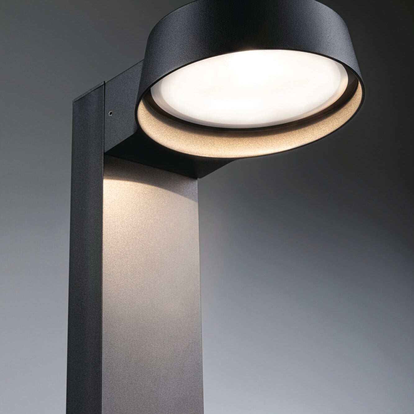 Introducing the Paulmann Outdoor Capea Grand 12.5W LED Bollard Light in Anthracite—an elegant addition to any outdoor space. This modern lamp post, with its circular top, blends style and durability seamlessly while offering IP44 protection to withstand various weather conditions against a neutral backdrop.