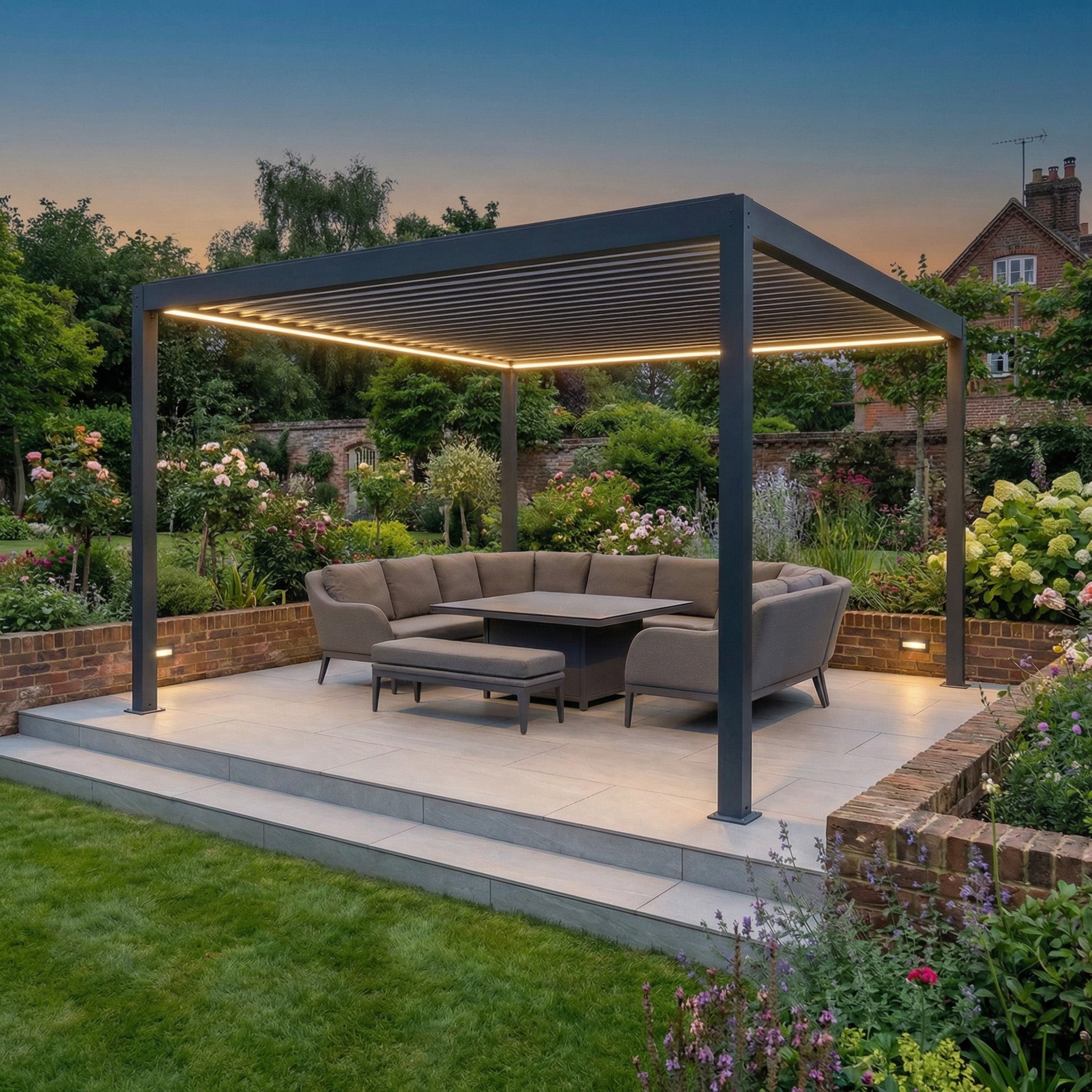 PergoSTET Plus Frame Only 4m x 4m Square Pergola with LED Lighting in Grey, shown at dusk on a patio with gray sectional sofa and table in a lush garden, highlights the latest in modern pergola design.