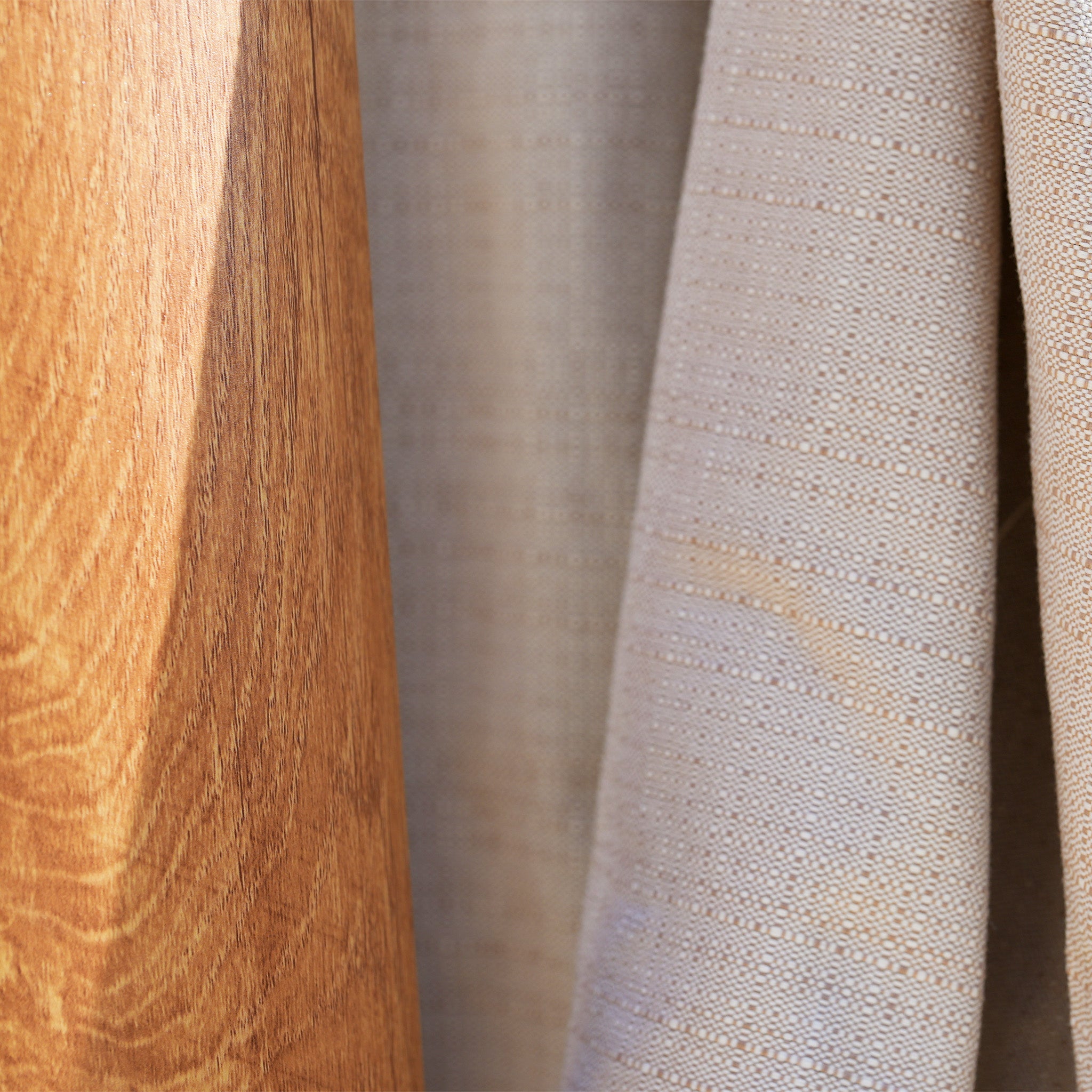 Close-up of textured, durable olefin fabric next to wood, highlighting contrast. Perfect for the Finca 4m x 3m Cantilever Parasol in Sand, offering style and sun protection.
