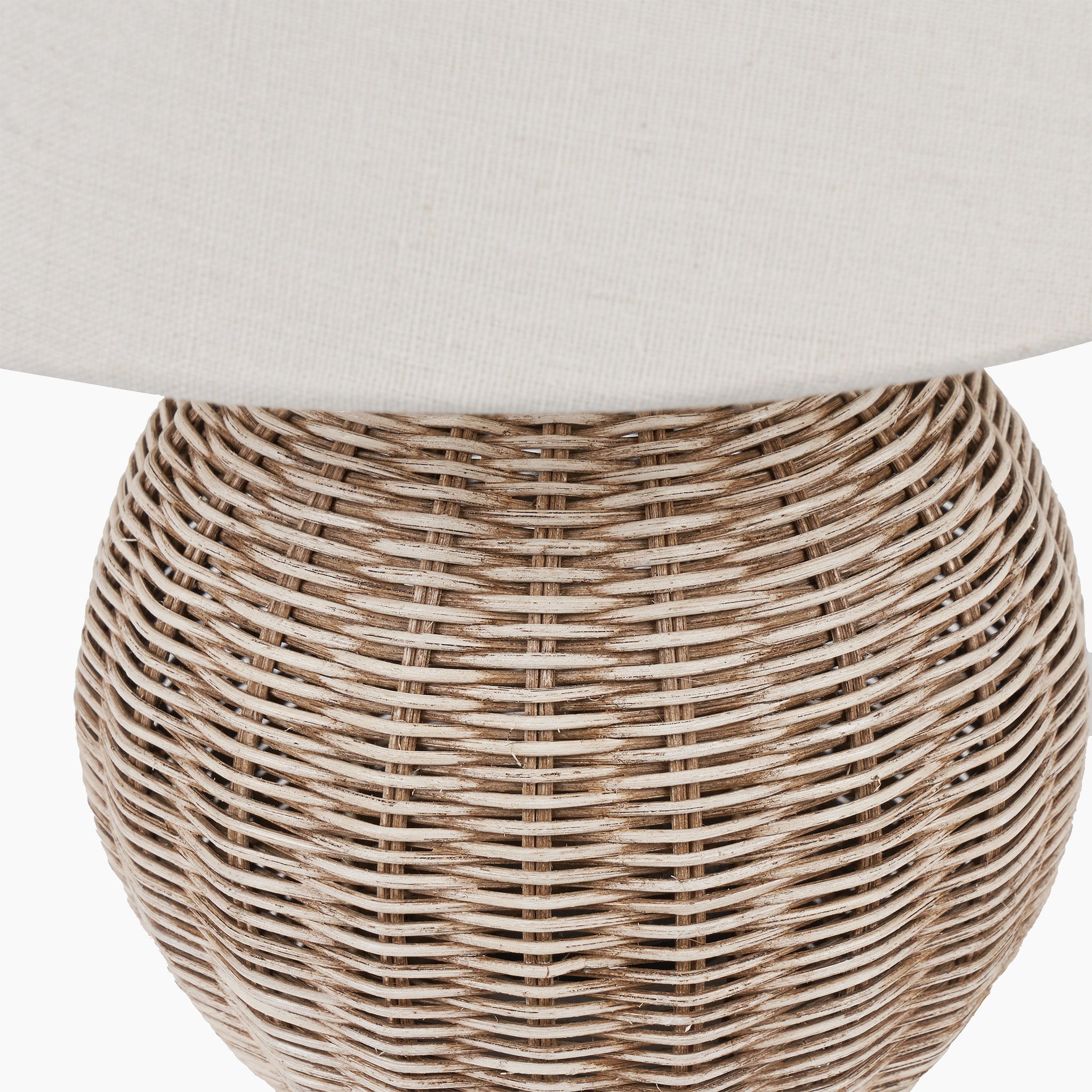 Close-up of the Pacific Lifestyle Raffles Small Rattan Cream Wash Table Lamp showcasing its intricately woven base and antique cream wash finish, topped with a white fabric lampshade.