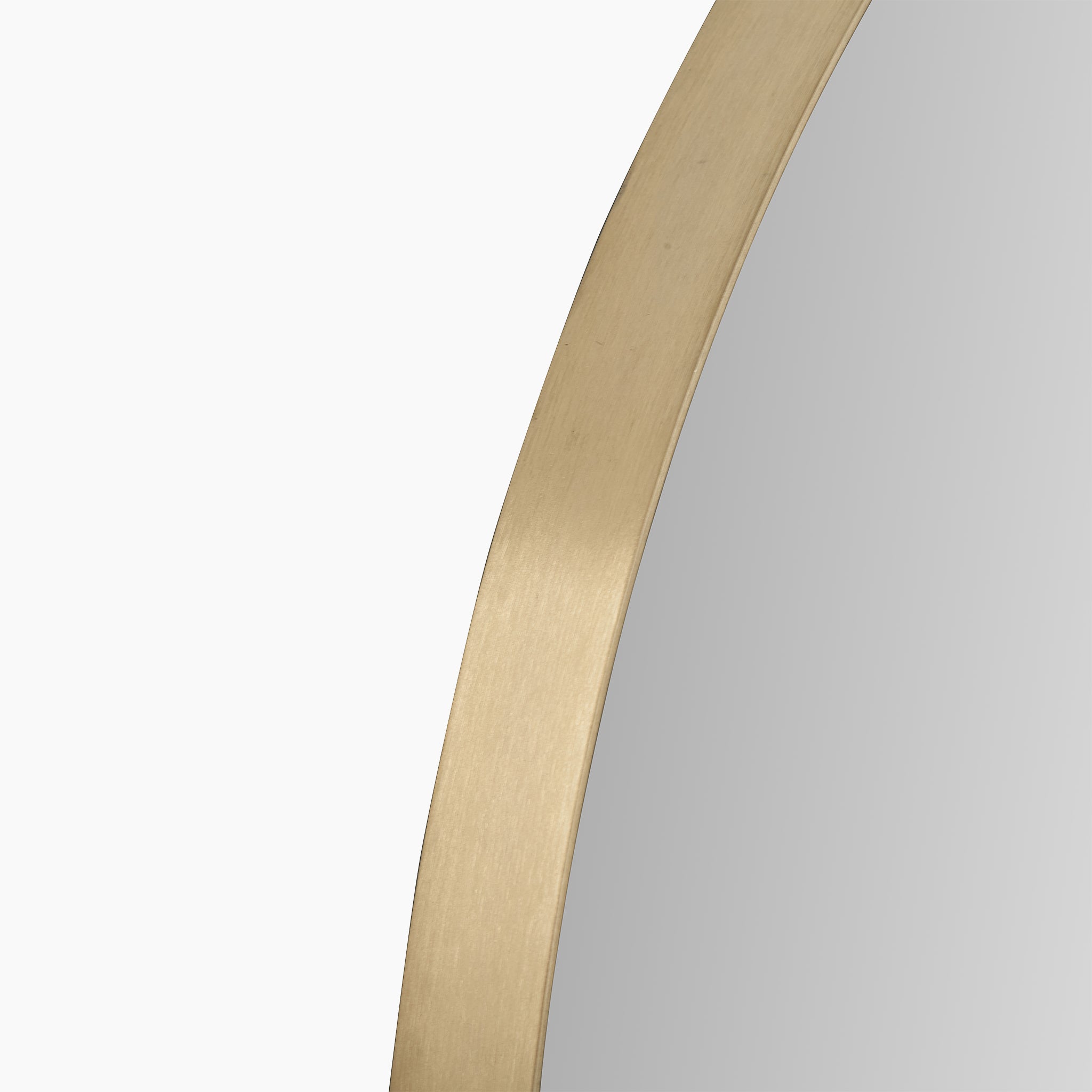 A close-up of the Pacific Lifestyle Brushed Gold Metal Slim Frame Round Wall Mirror Small shows its thin, brushed gold-like metal frame encircling a circular brass mirror on a white background.
