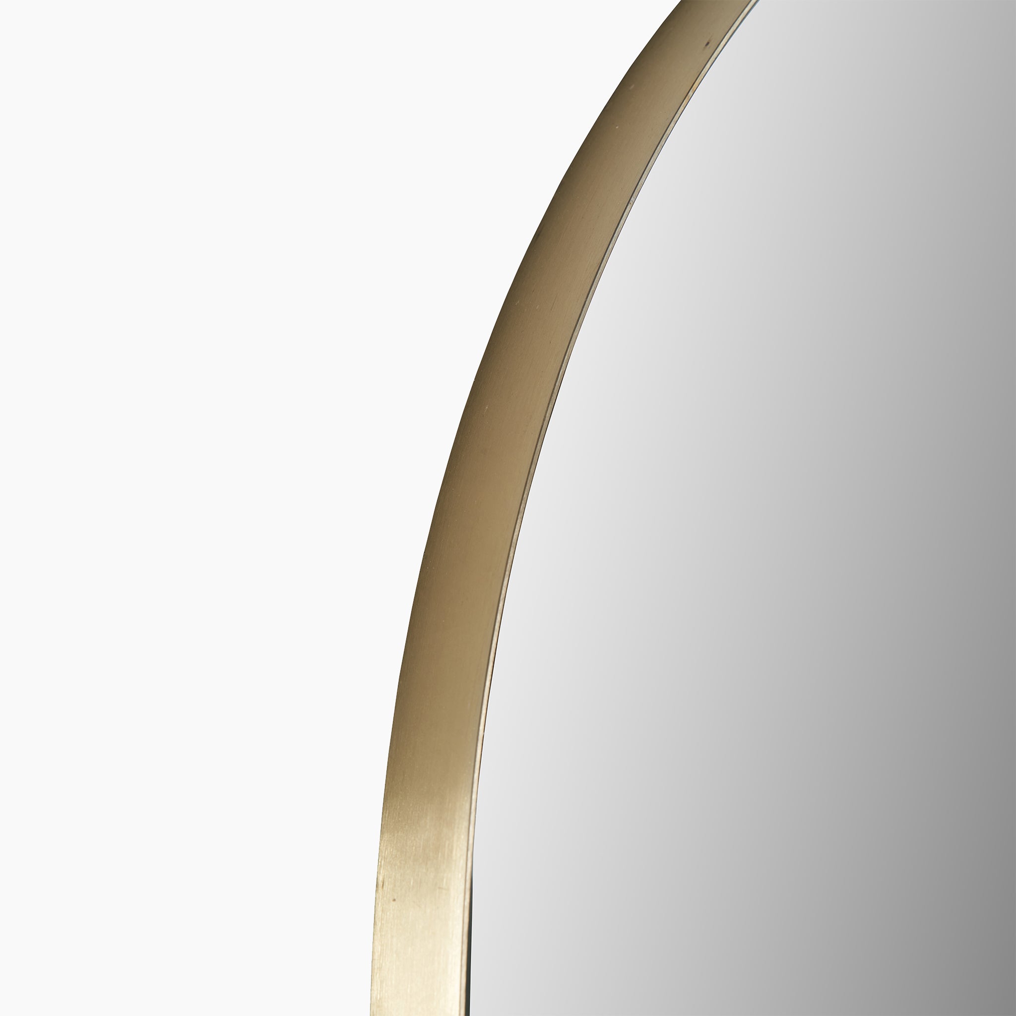Close-up of the Pacific Lifestyle Brushed Gold Metal Slim Frame Arch Floor Mirror, highlighting minimalist decor against a pristine white background.