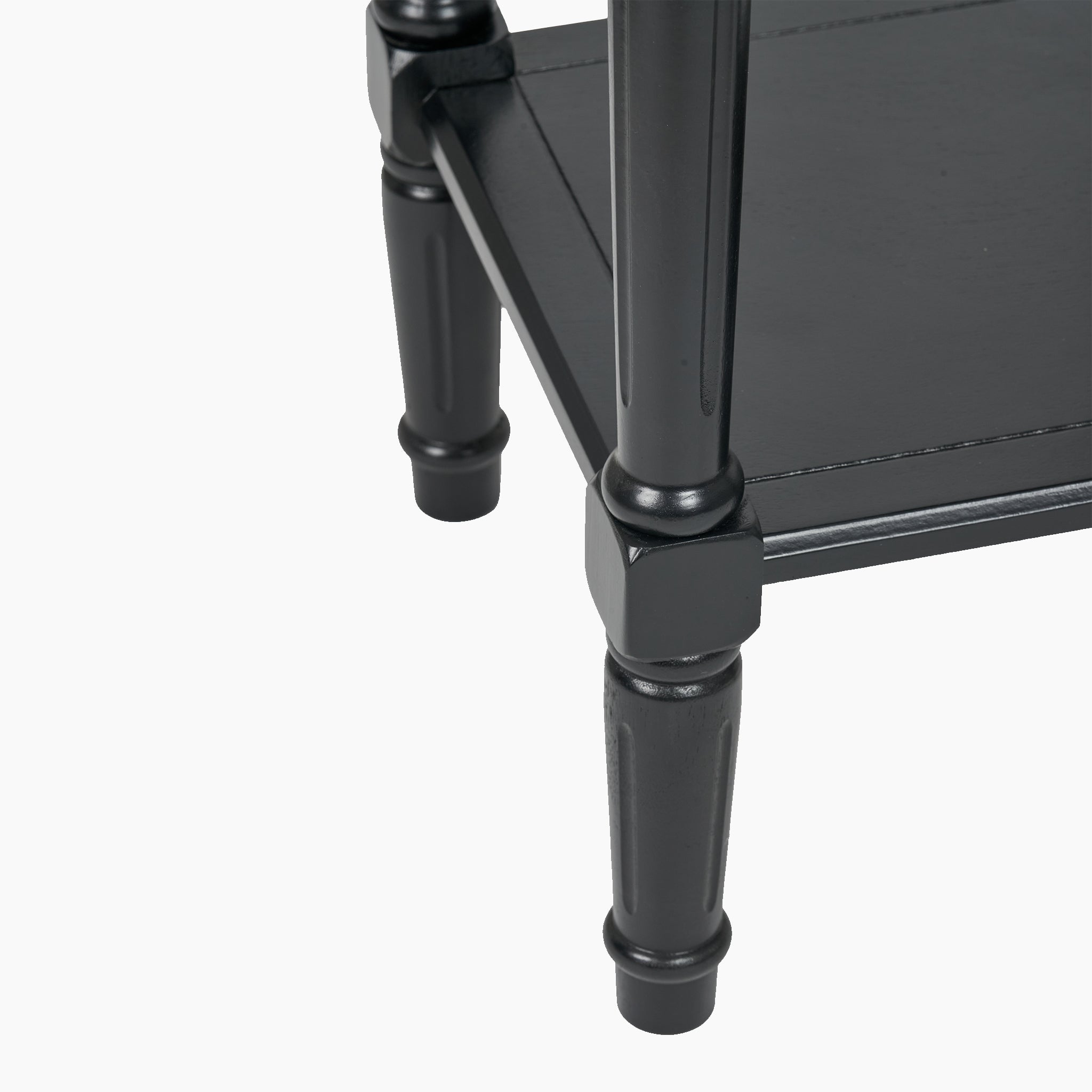Close-up of an elegantly crafted Heritage Black Pine Wood Accent Table, showcasing sleek, polished black legs and a lower shelf by Pacific Lifestyle.