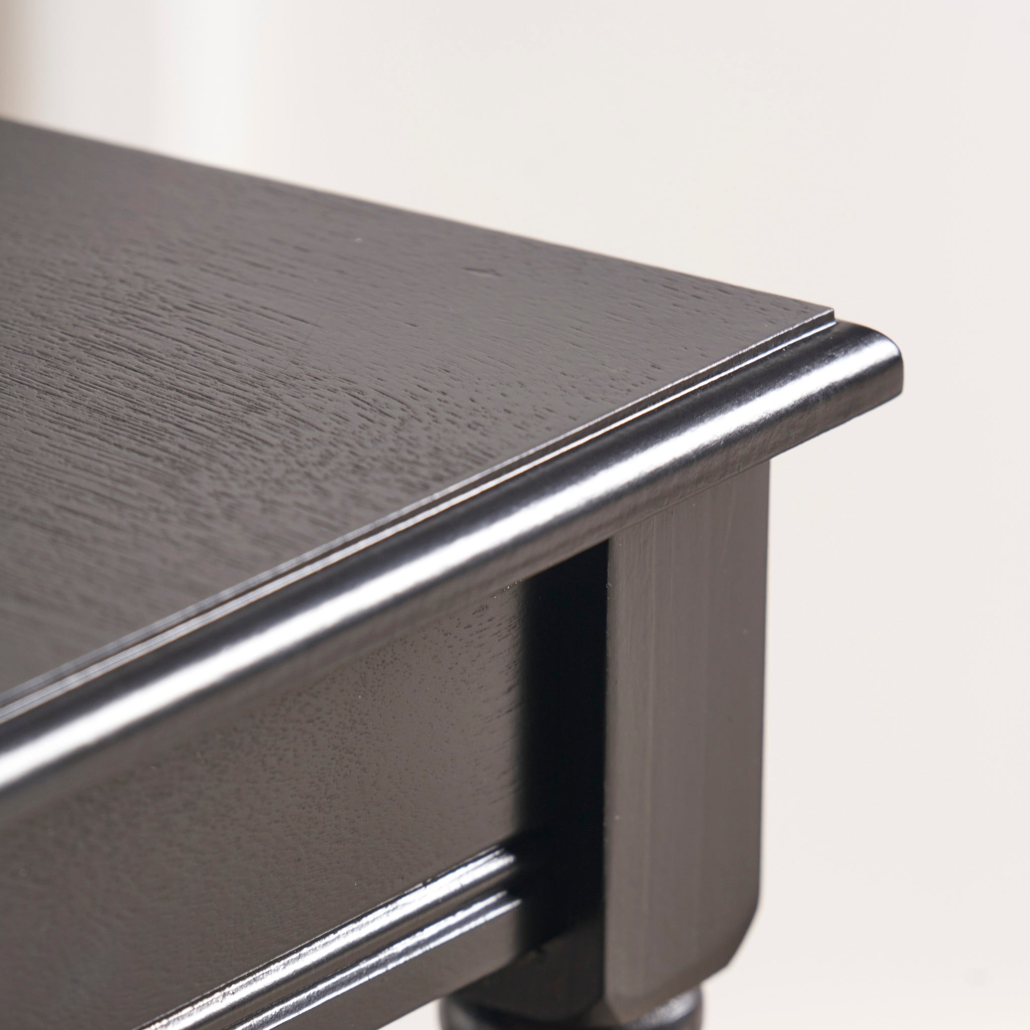 Close-up of a corner from the Pacific Lifestyle - Heritage Black Pine Wood Accent Table, highlighting its glossy finish.