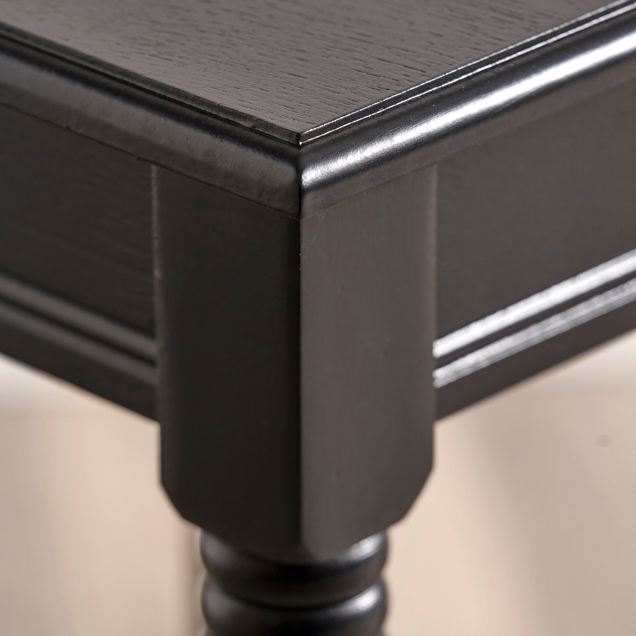 Close-up of a corner from the Pacific Lifestyle - Heritage Black Pine Wood Accent Table, highlighting intricate craftsmanship and a sleek finish.