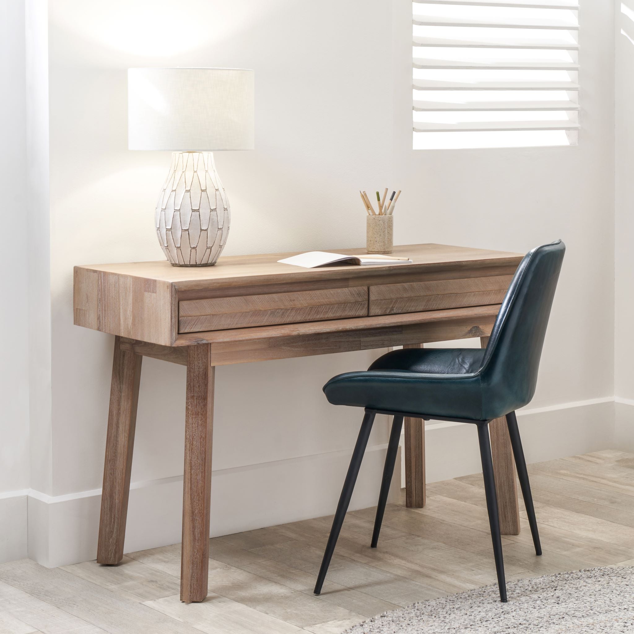 Introducing the Kalmar Collection: The Pacific Lifestyle Sand Wash Acacia Wood 2 Drawer Desk embodies Scandi style with its elegant design. Enhance your workspace by pairing it with a dark chair in a bright room to achieve a perfect blend of elegance and functionality.