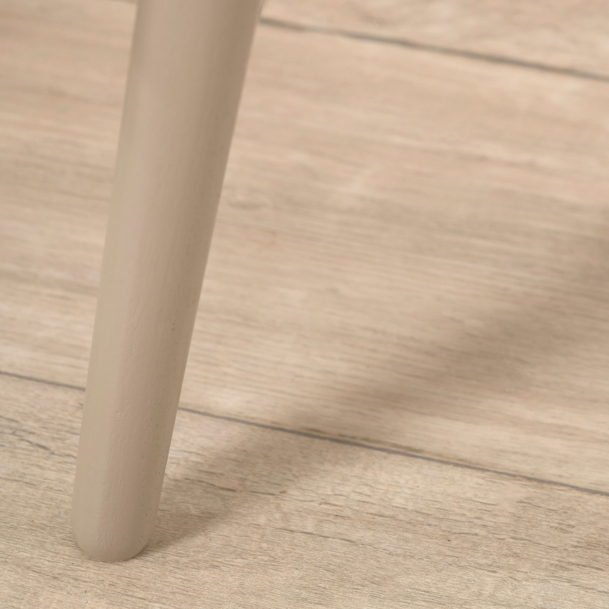 Close-up of the Pacific Lifestyle Devonshire Putty Pine Wood Side Table on a light wooden floor, highlighting its compact silhouette and subtle mid-century appeal.