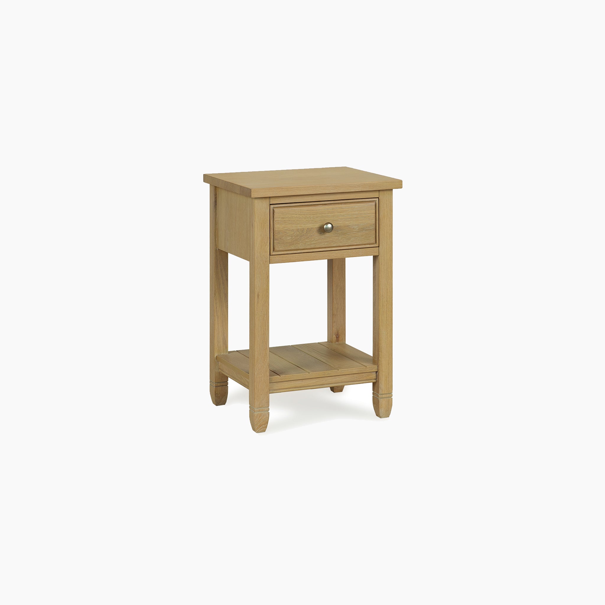The Amberley Bedside Table in Light Oak is a light wood nightstand featuring one drawer and a lower shelf, shown against a plain white background.