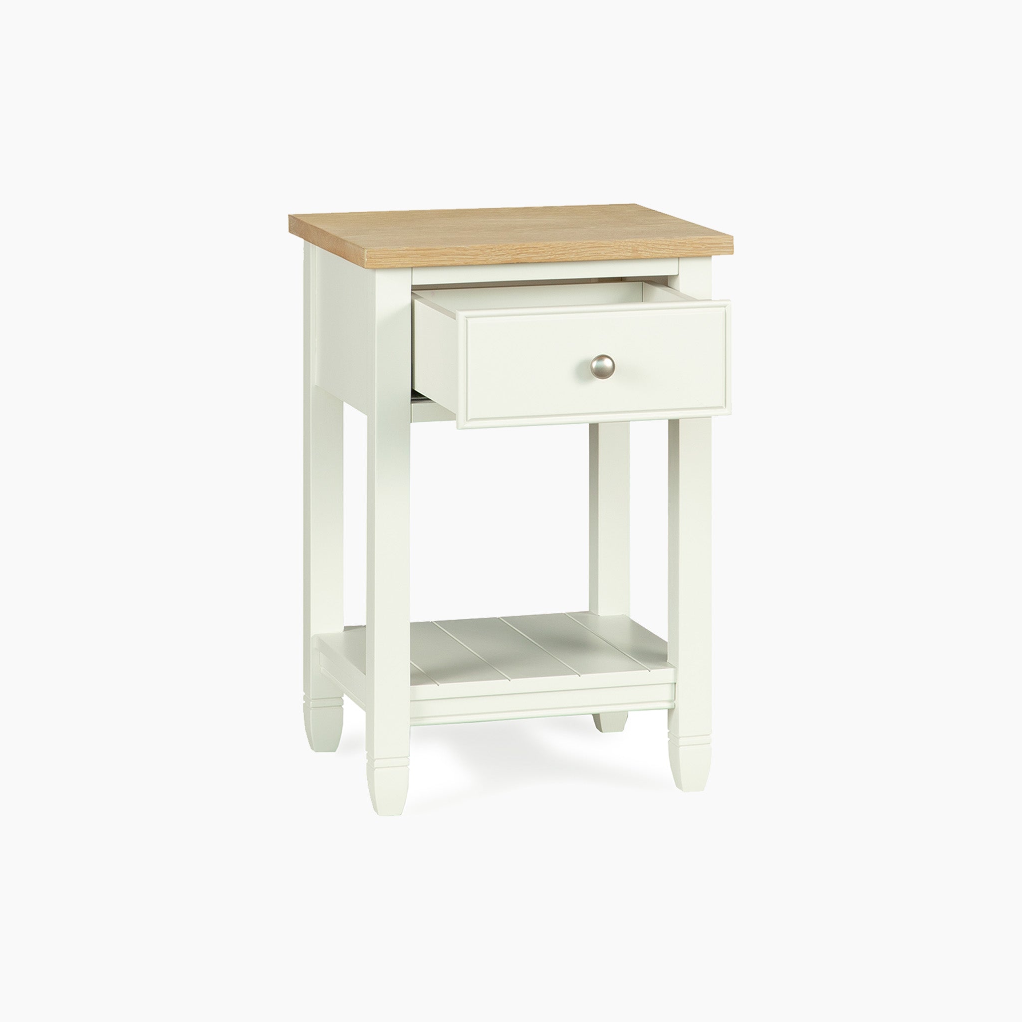 The Amberley Bedside Table in Warm White features a light wood top, one open drawer, and a lower shelf—an ideal nightstand to add charm to modern country interiors.