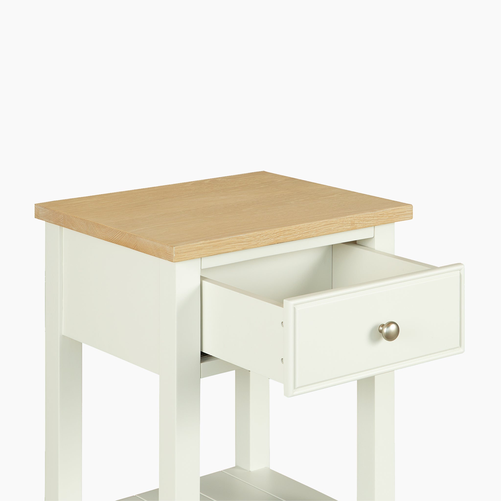 The Amberley Bedside Table in Warm White features a white base, light wood top, and open drawer—ideal for modern country interiors. Shown against a plain white background.