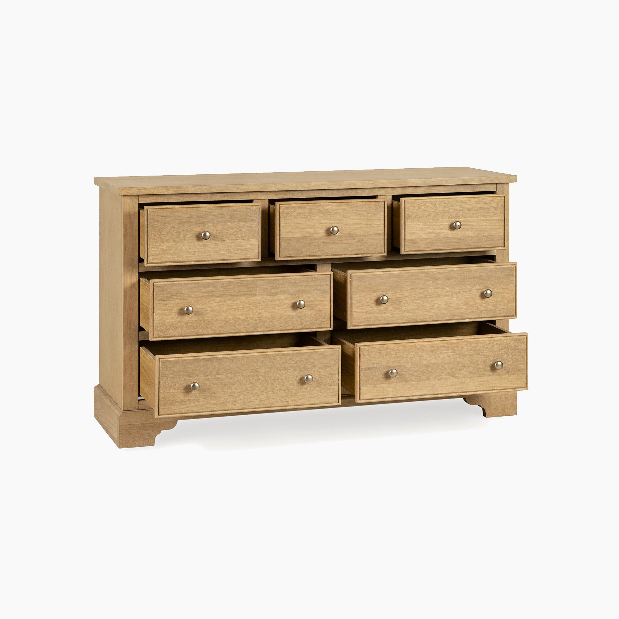 The Amberley 3 Over 4 Chest of Drawers in Light Oak, featuring seven spacious drawers with four slightly open, is perfect for bedroom storage and sits on a plain white background.