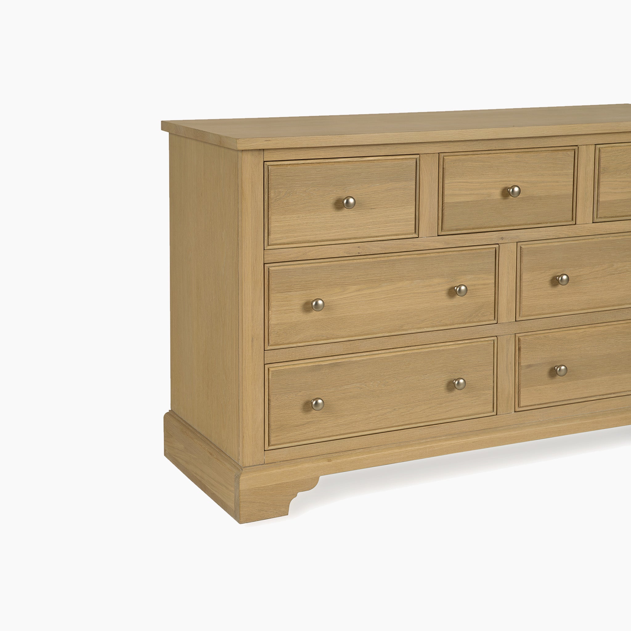 The Amberley 3 Over 4 Chest of Drawers in Light Oak features seven drawers with metal knobs, providing stylish bedroom storage in a modern oak finish.