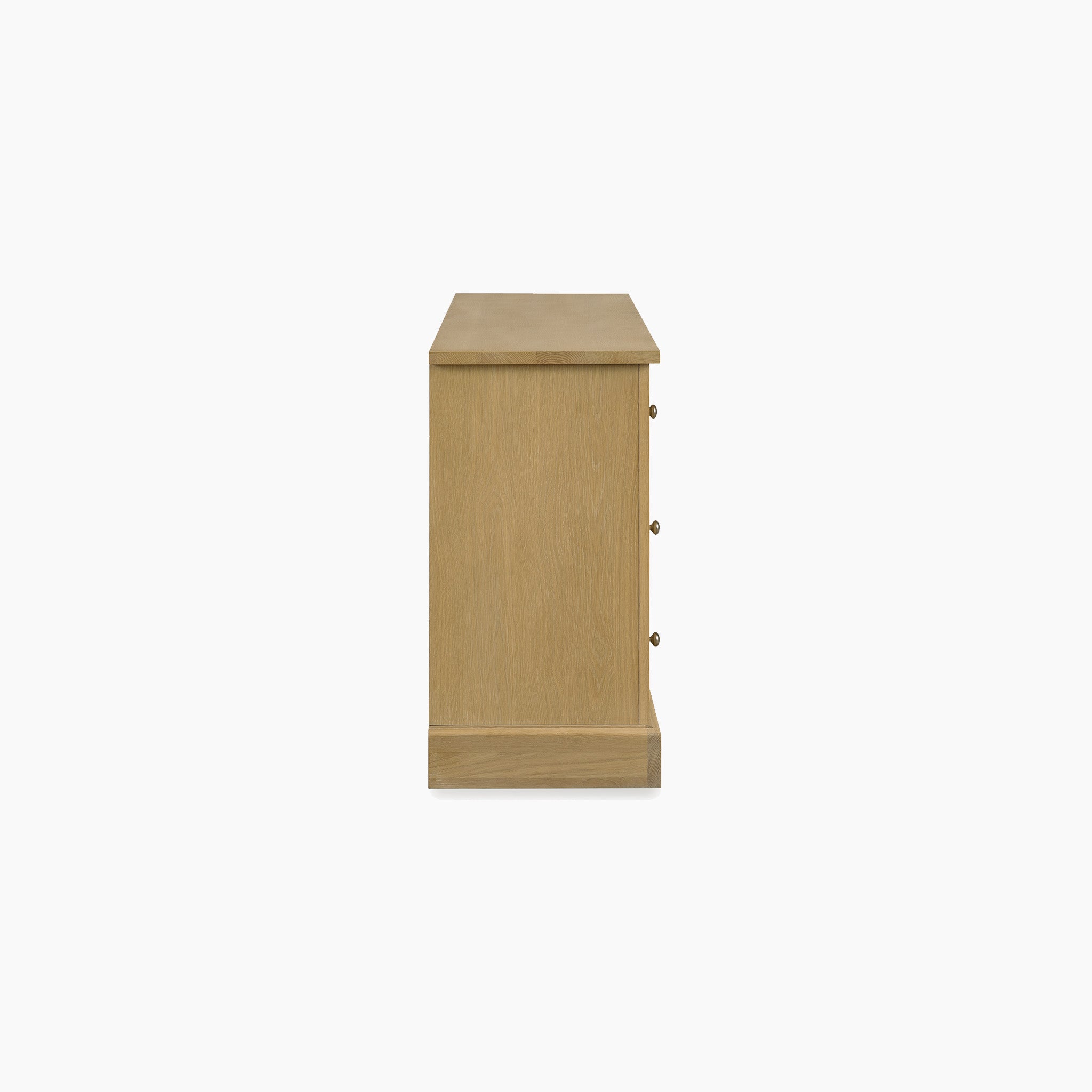 Side view of the Amberley 3 Over 4 Chest of Drawers in Light Oak, featuring three round knobs and stylish bedroom storage, set against a white background.