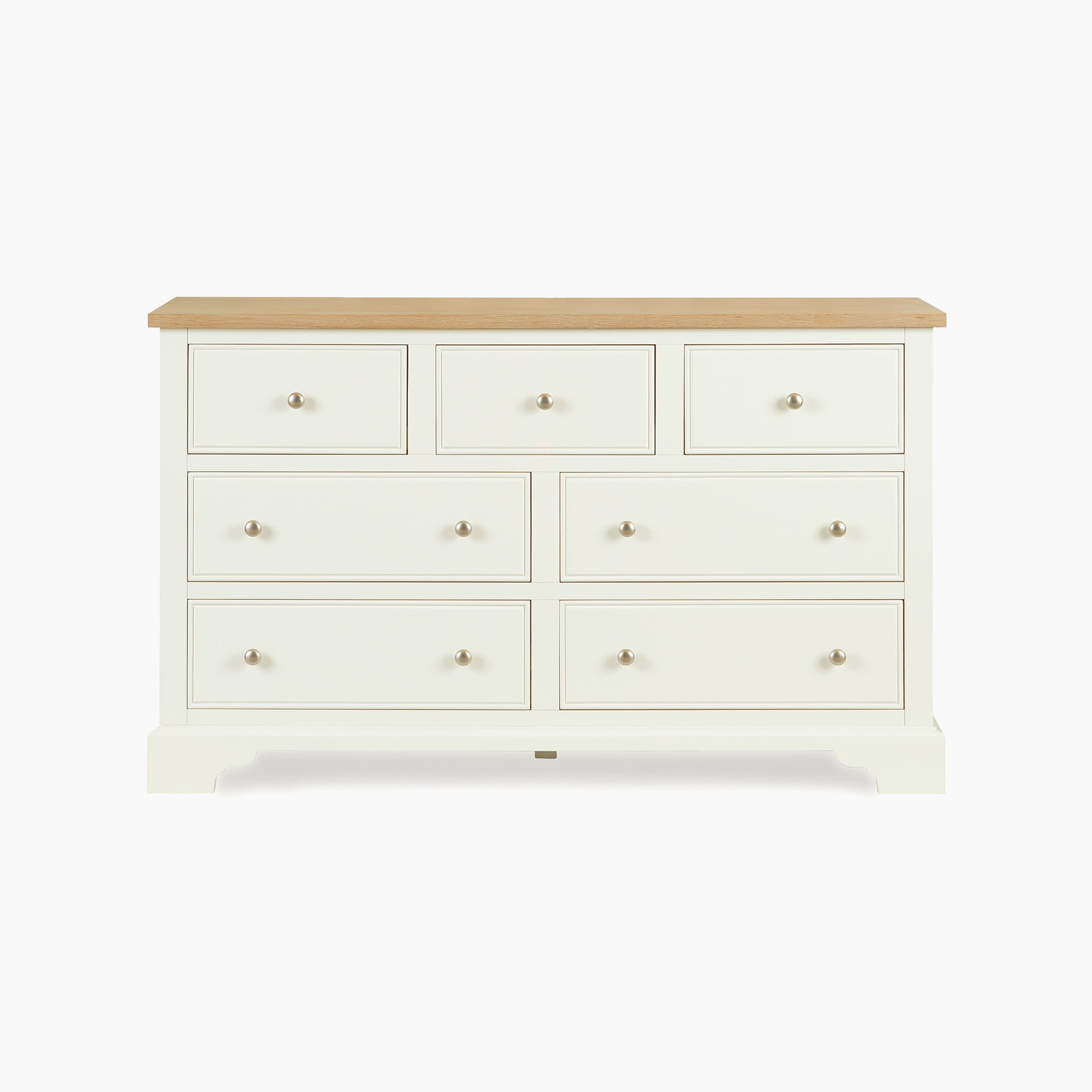 The Amberley 3 Over 4 Chest of Drawers in Warm White features seven spacious drawers and a stylish oak top, displayed against a plain white background.