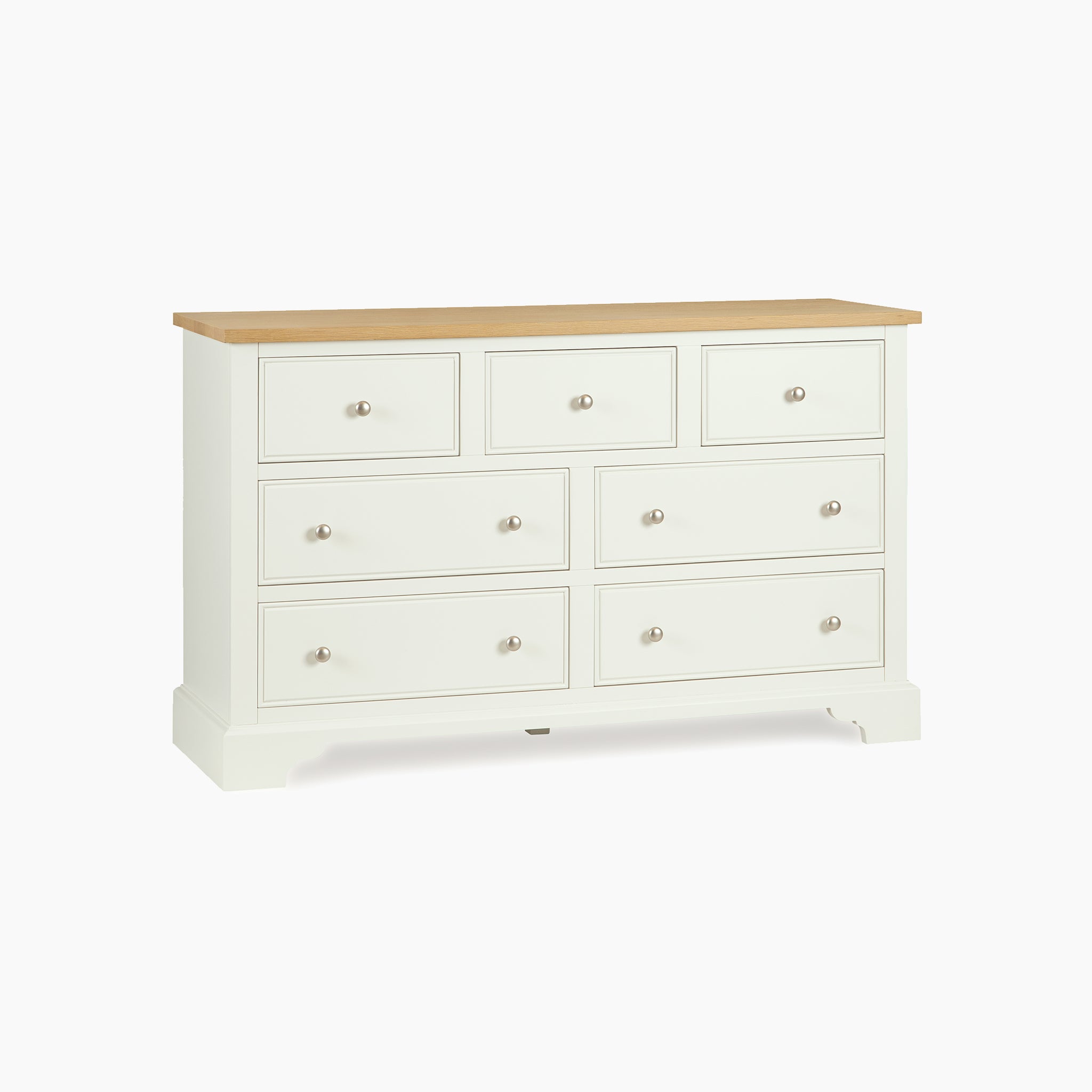The Amberley 3 Over 4 Chest of Drawers in Warm White features seven spacious drawers with a smooth oak top, shown against a plain white background.
