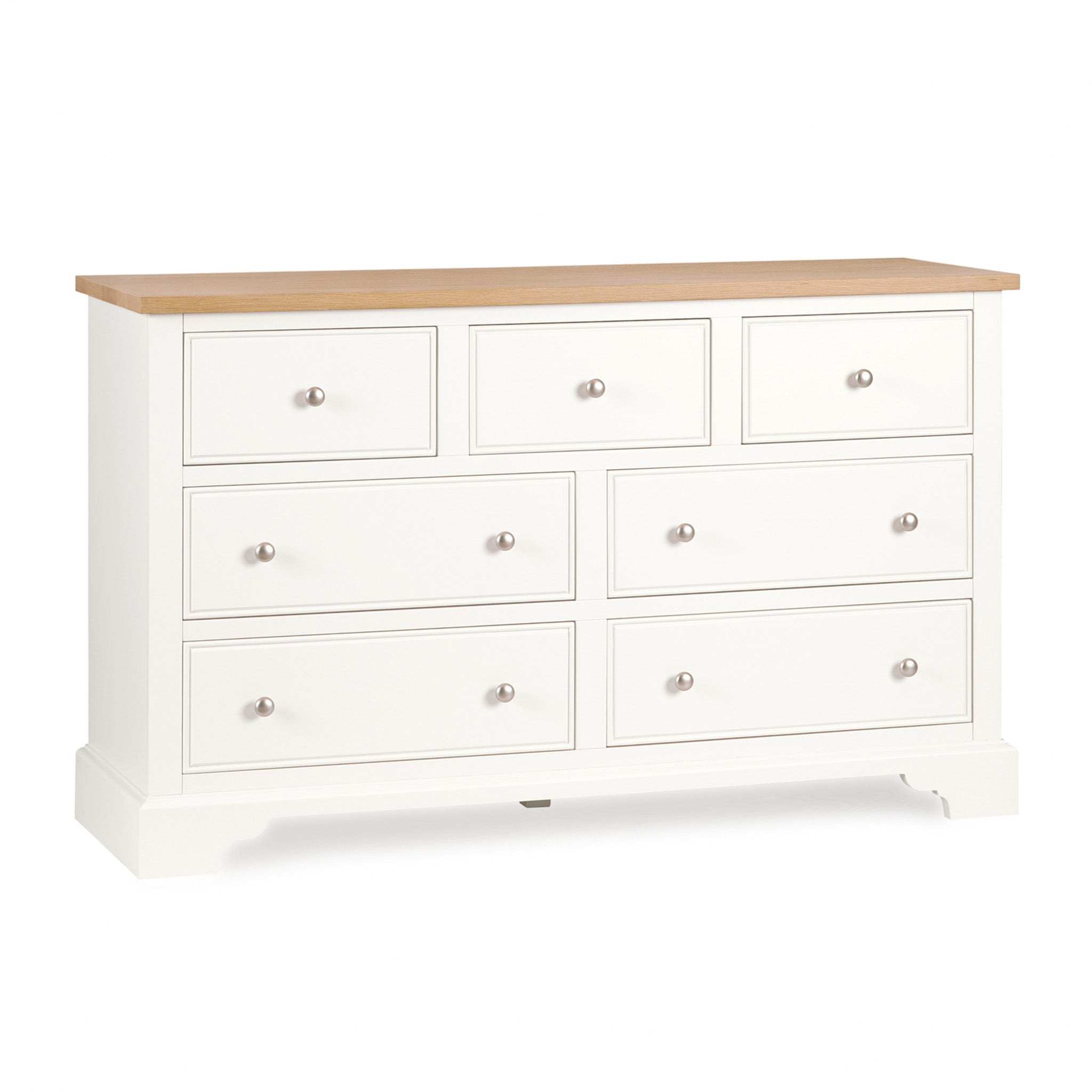 The Amberley 3 Over 4 Chest of Drawers in Warm White features seven spacious drawers, an elegant oak top, and round silver knobs for a classic look.