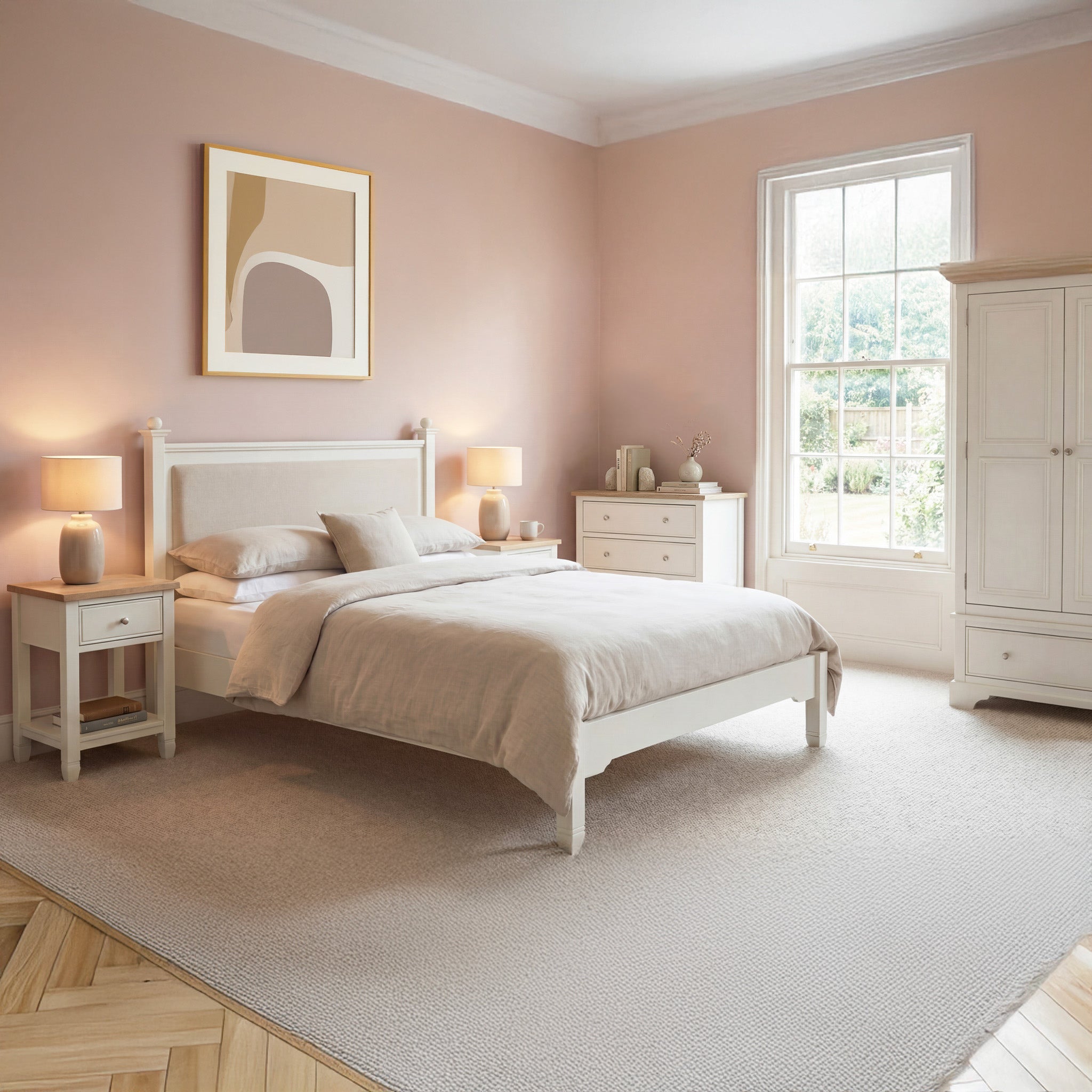 A cozy bedroom featuring the Amberley 4ft 6" Double Bed Frame in Warm White, soft pink walls, matching furniture, lamps, underbed storage, and a large window.