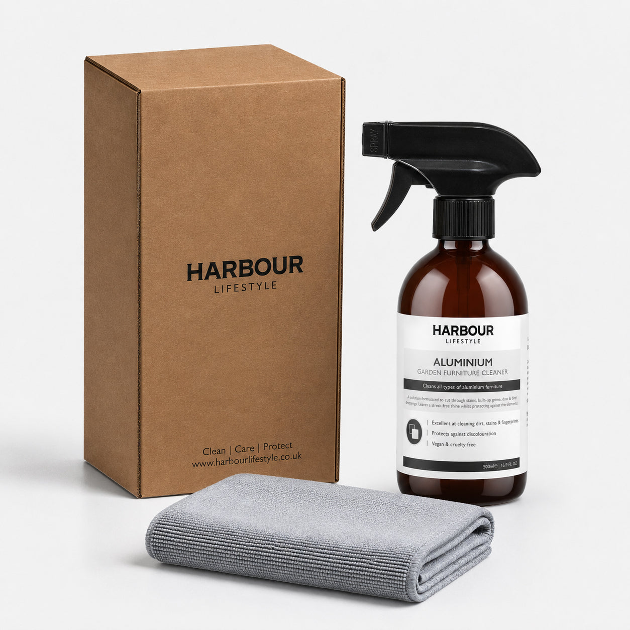 Brown box, spray bottle labeled “Outdoor Aluminium Furniture Cleaner,” and a folded gray cloth on a white background—everything you need for effortless care with our Outdoor Aluminium Furniture Cleaner.