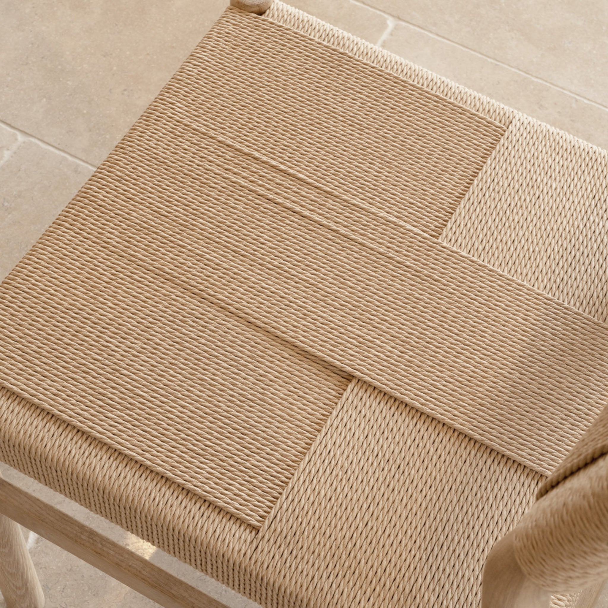 Close-up of a woven chair seat featuring a geometric, two-direction weave in natural fibers, ideal for pairing with the Amberley 4-6 Seater Round Extending Dining Table in Light Oak.