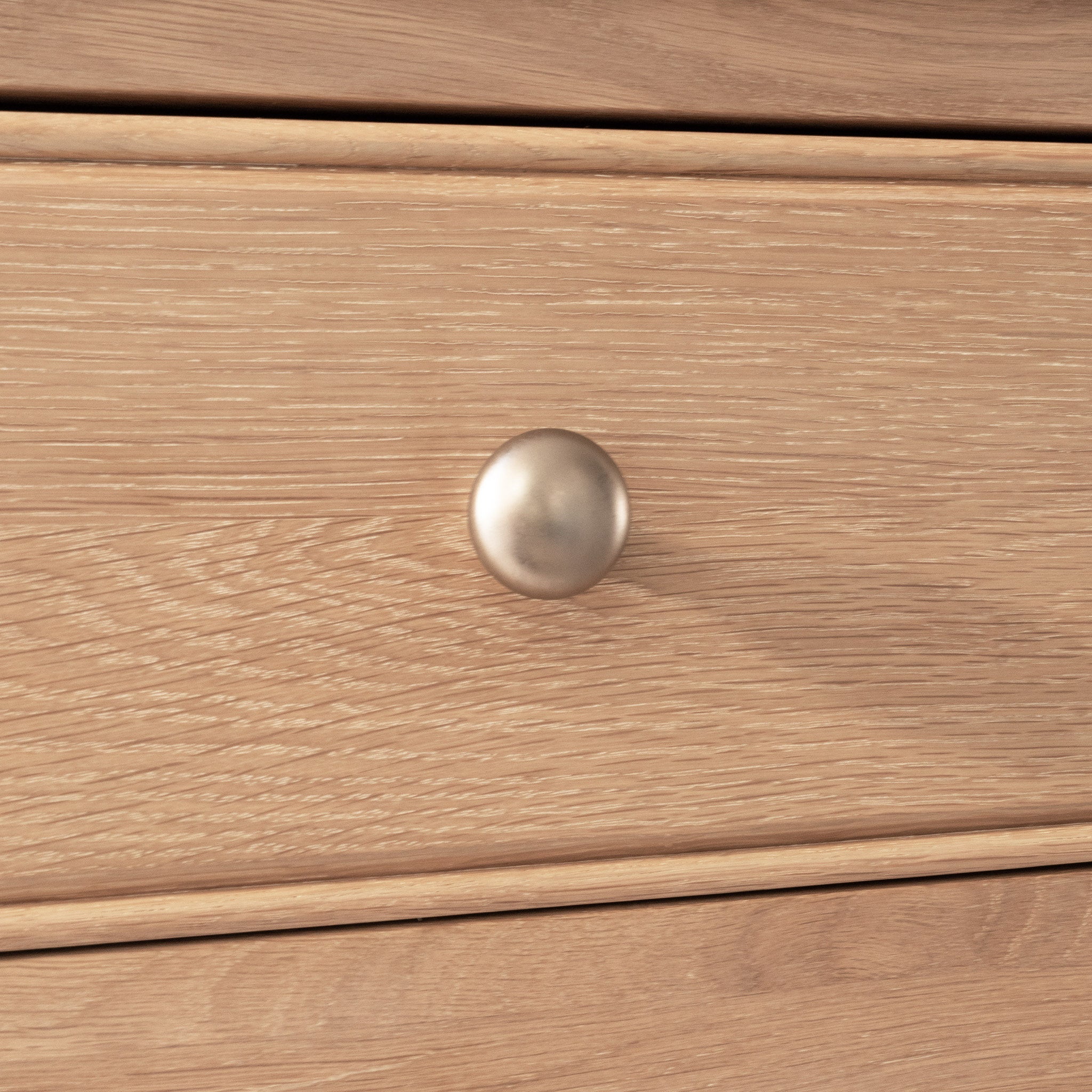 Close-up of a wooden drawer with a round silver knob, part of the Amberley Large Bookcase in Light Oak.