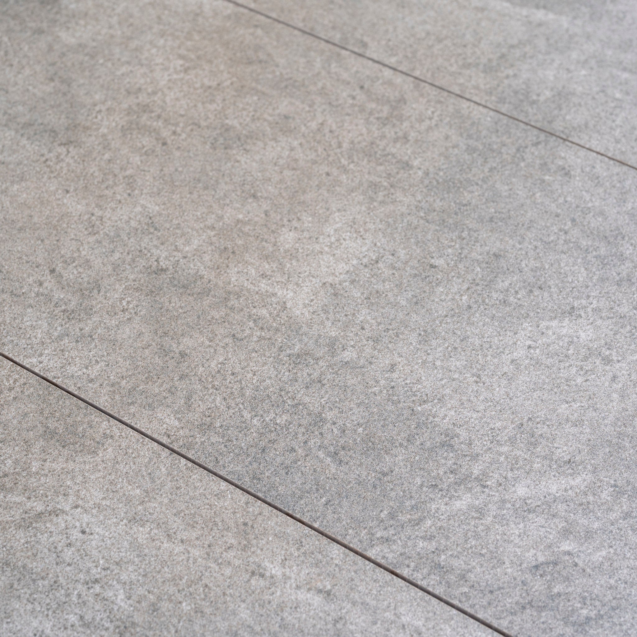 Close-up of light gray stone tiles with visible grout lines and textured surface, ideal for pairing with modular outdoor furniture like the Andora Large Corner Sofa Set with 2 in 1 Table in Weathered Brown.