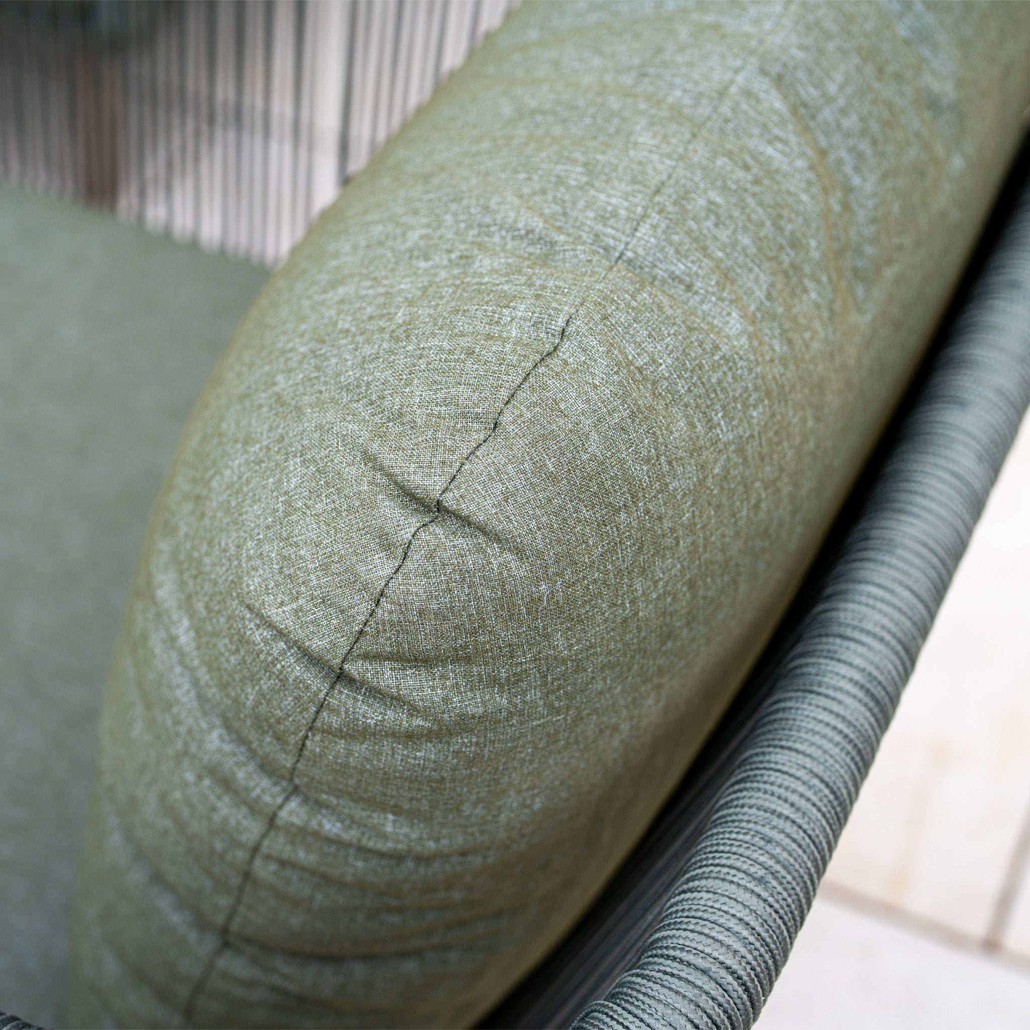 Close-up of a green cushioned armrest with fabric upholstery on the modern Ascot Corner Dining Set with Armchair in Forest Green.