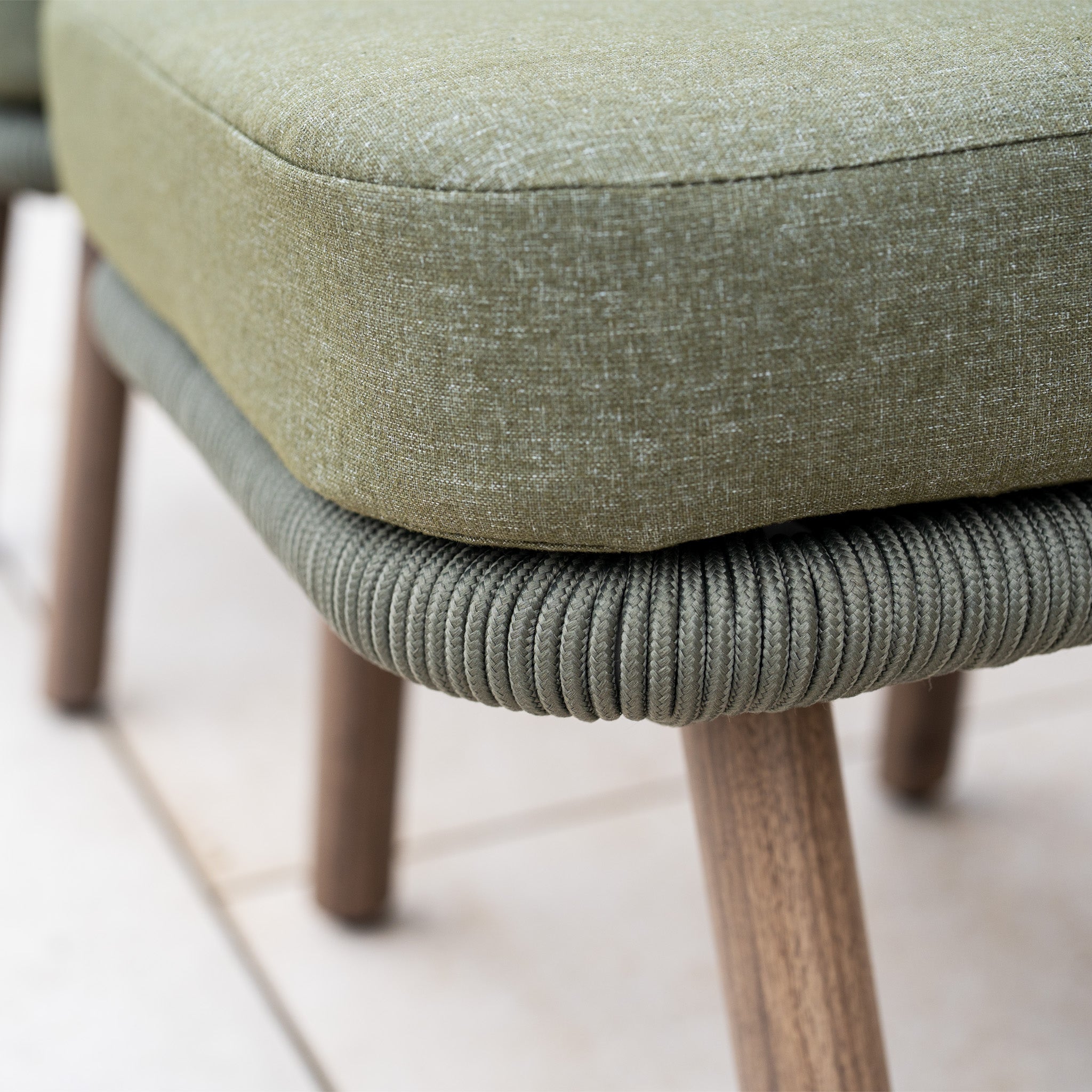 Close-up of the forest green upholstered armchair seat with wooden legs on a tiled floor, part of the Ascot Corner Dining Set with Armchair in Forest Green—ideal as stylish garden furniture or an elegant outdoor dining set.