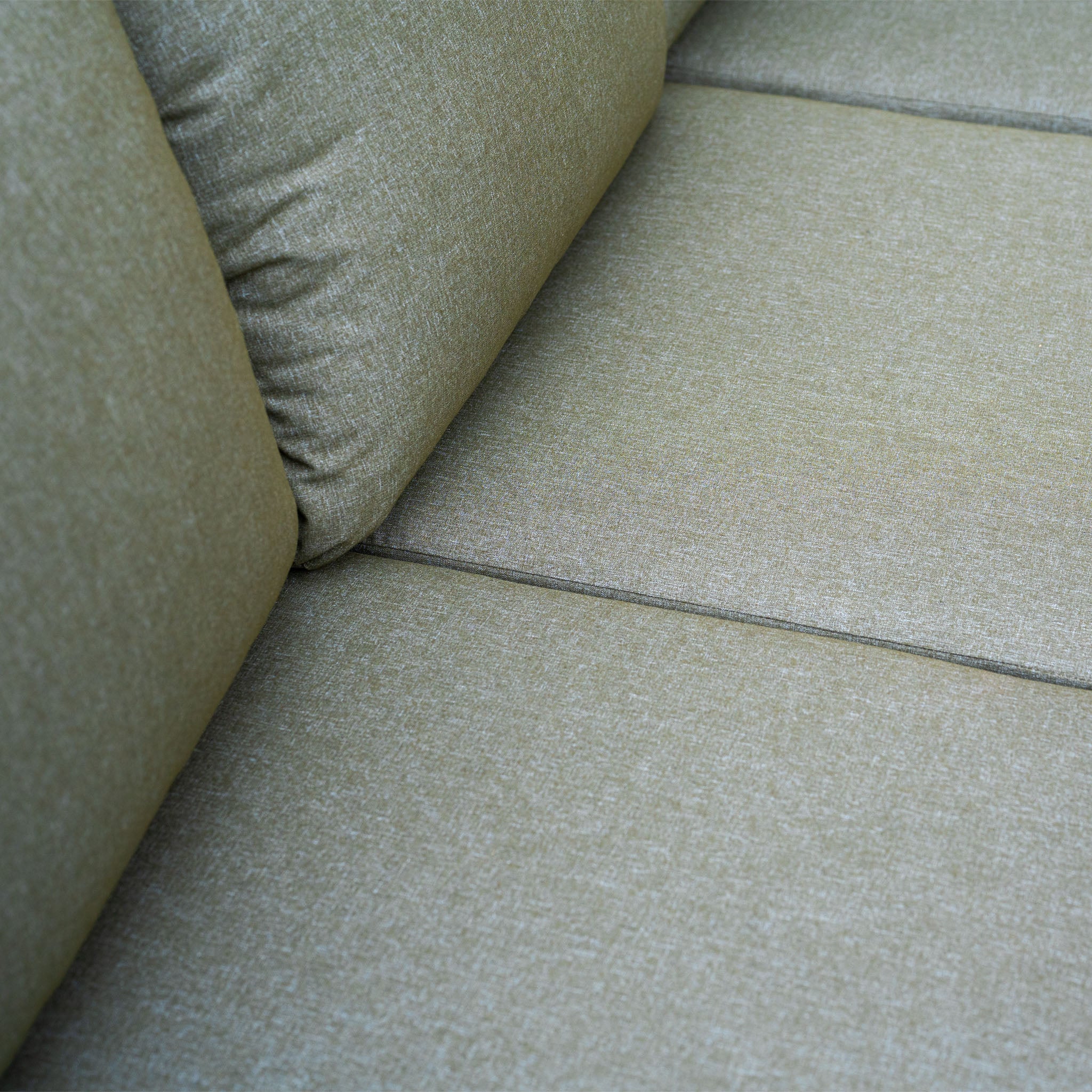 Close-up of a light green fabric sofa with visible cushions and seat seams, ideal for pairing with the Ascot Corner Dining Set with Armchair in Forest Green or enhancing your outdoor dining area.