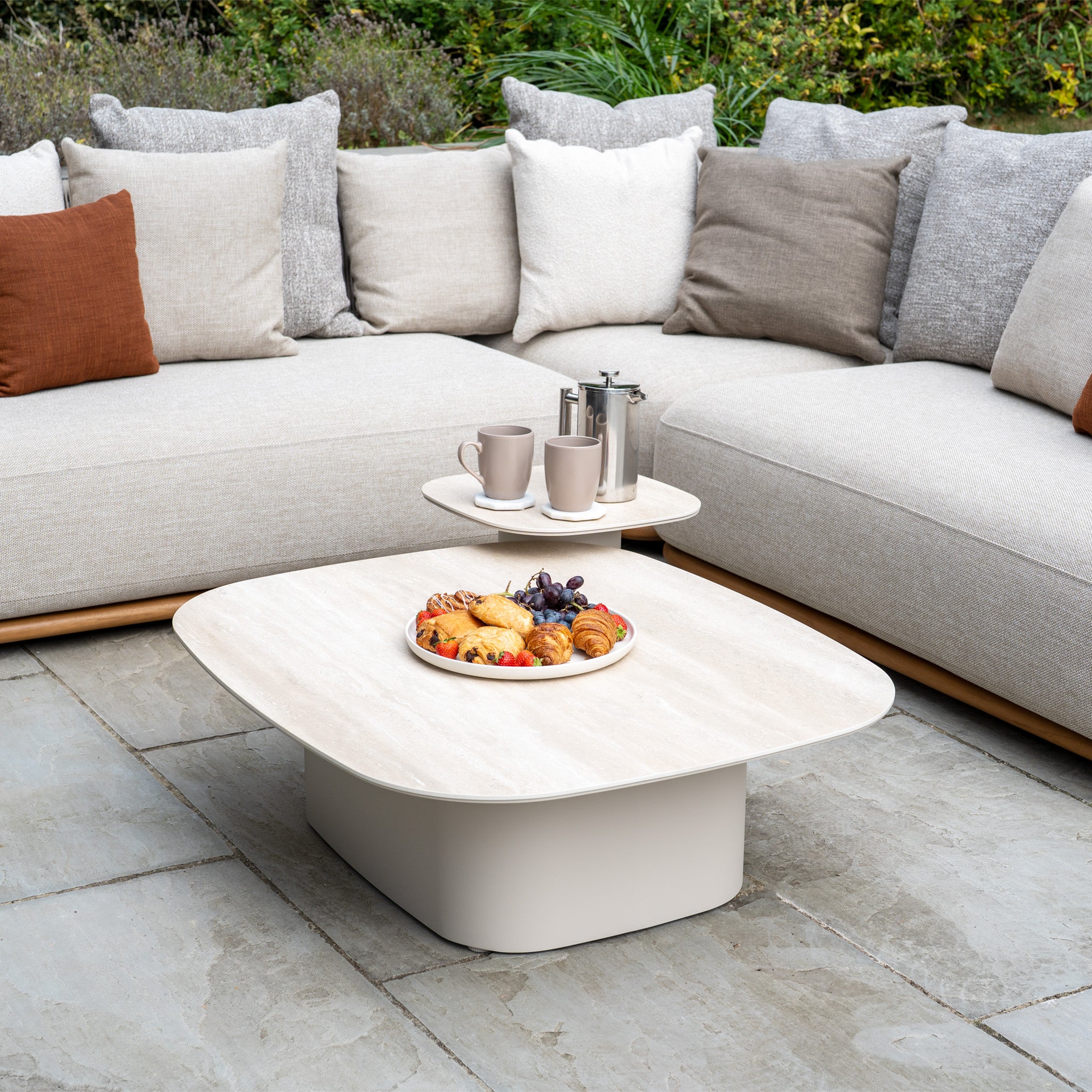 The Avola Corner Sofa Set in Fawn features weather-resistant olefin cushions and a table perfect for pastries, fruit, coffee cups, and a French press—an ideal outdoor garden sofa for stylish relaxation.