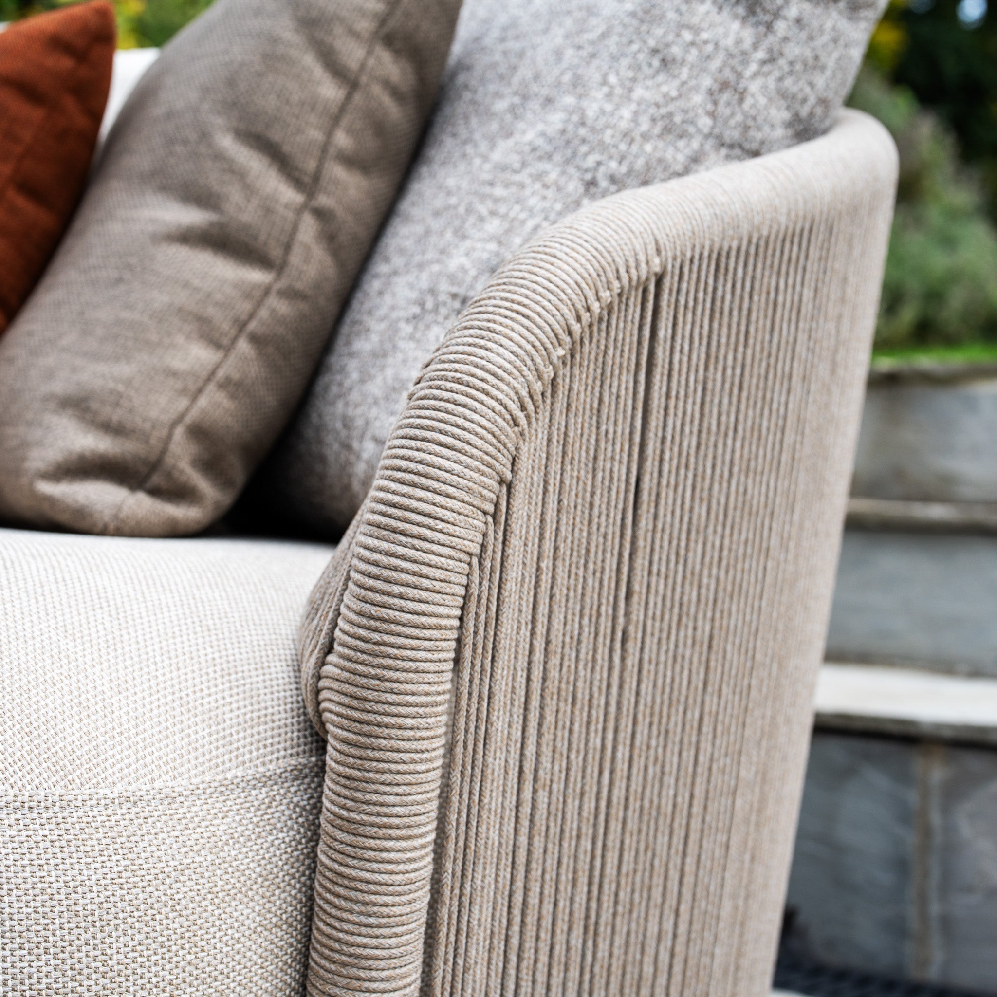 Close-up of the Avola Corner Sofa Set in Fawn, featuring weather-resistant olefin upholstery and neutral cushions, placed outdoors near stone steps.