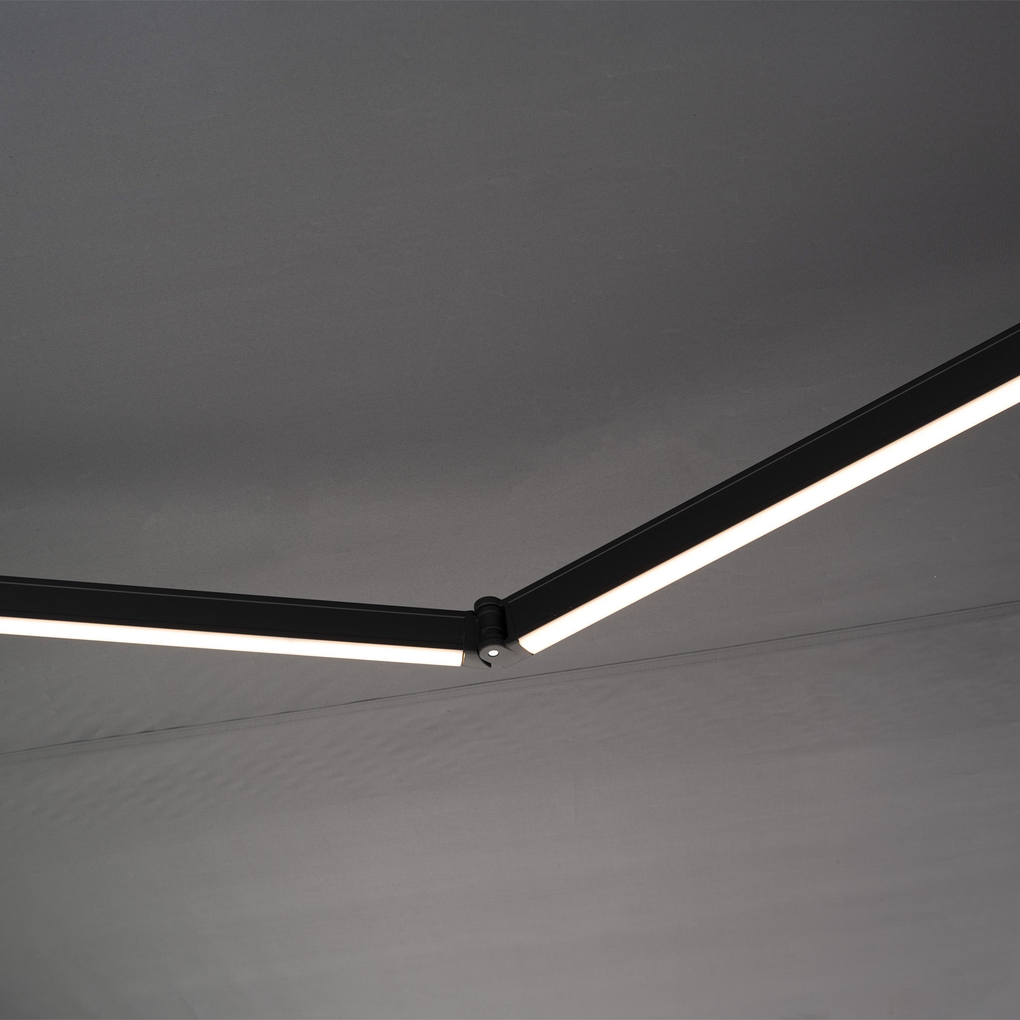 Minimalist LED ceiling lights with black frames echo the sleek design of the 3m x 2m Electric Motorised Awning in Grey, crafted from waterproof acrylic fabric, both adding modern style to the space.