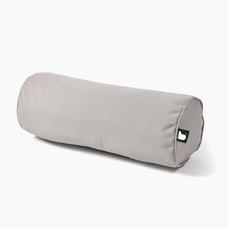The Outdoor B-Bolster Cushion in Silver Grey is a cylindrical pillow crafted from UV-resistant polyester, featuring a small black tag adorned with a white heart emblem. Perfect for enhancing your lounging experience.