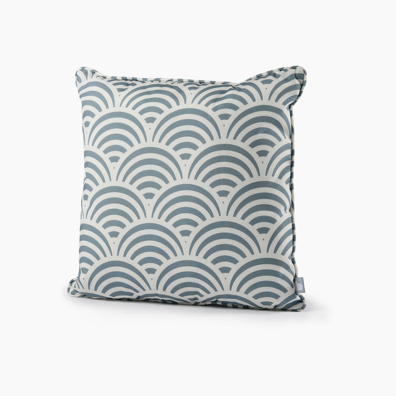 The Outdoor Shell B-Cushion in Sea Blue is a square throw pillow with a blue and white scallop pattern, crafted from splash-proof fabric and UV-resistant for long-lasting use.