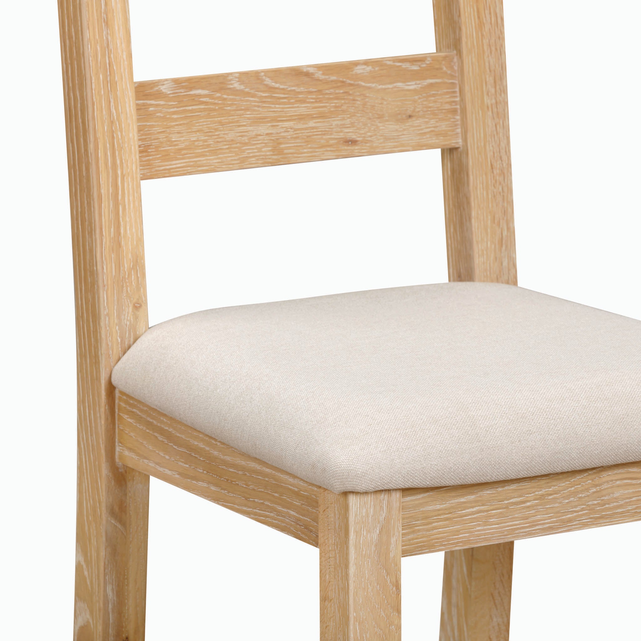 The Burford Set of 2 Ladderback Dining Chairs with Fabric Seat in Natural Oak showcases a natural oak finish and light beige upholstered fabric seats, complemented by a white background.
