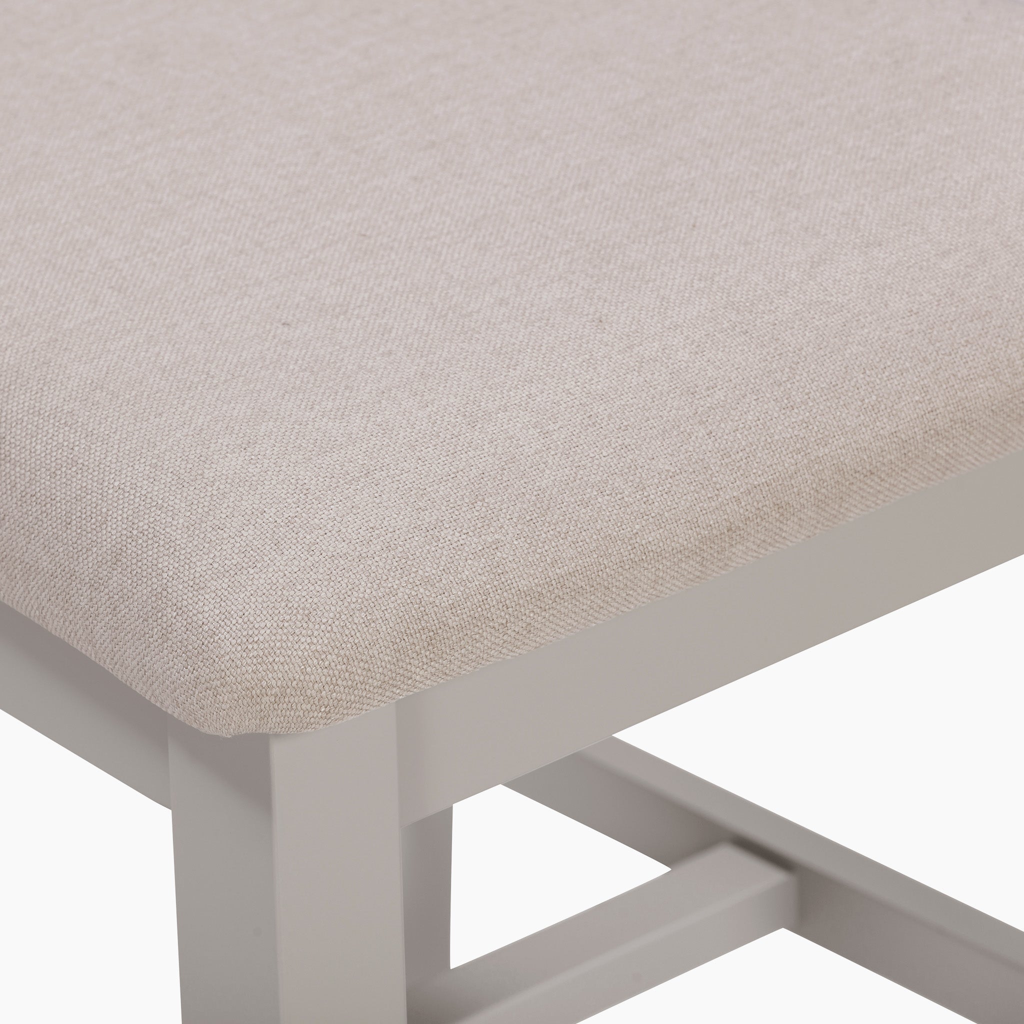 Close-up of a beige upholstered seat on a light gray wooden chair against a white background, perfectly complementing the elegance of the Burford 6 Seat Extending Dining Set in Pebble Grey.