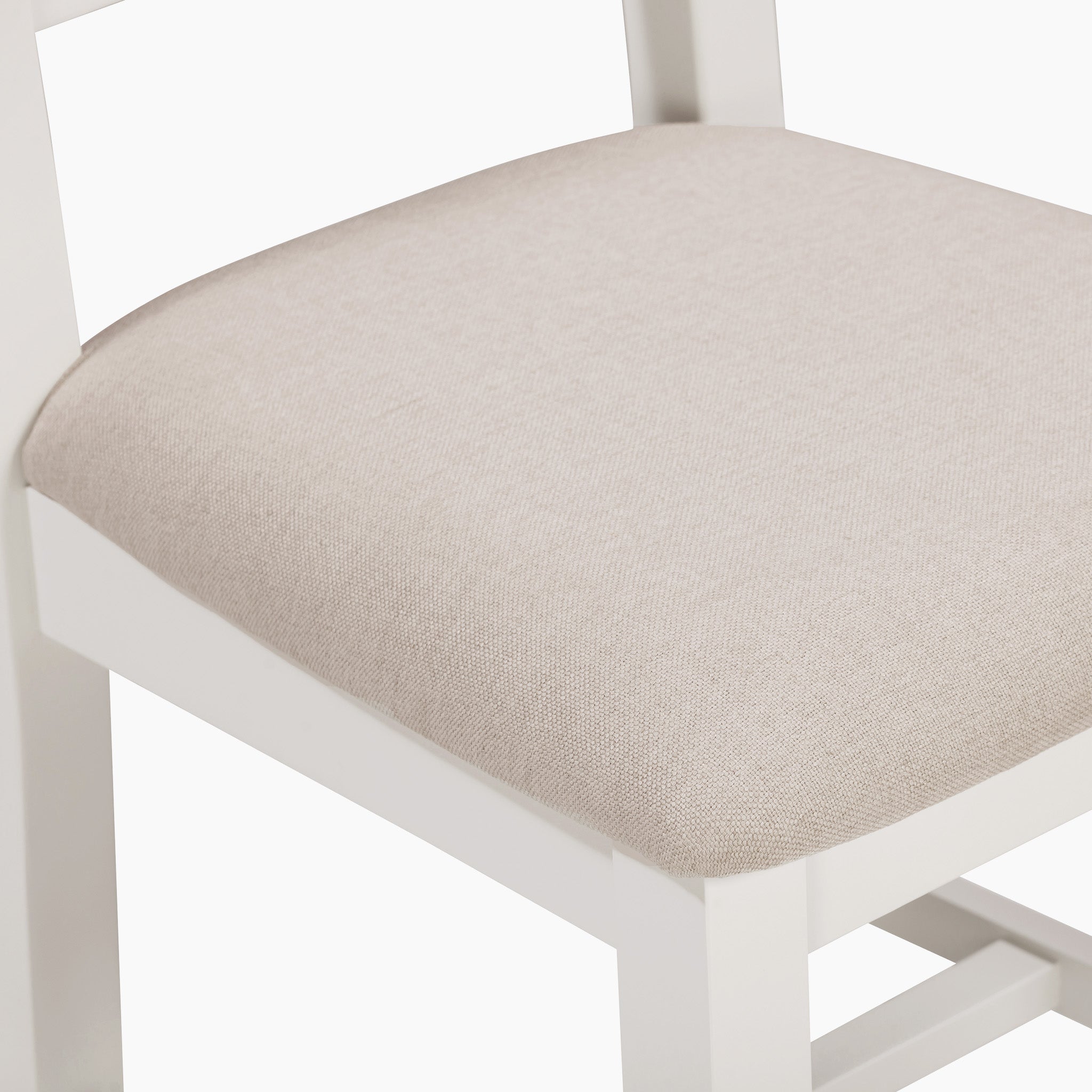 White wooden chair with a beige cushioned seat, perfectly complementing the warm white finish of the Burford 8 Seat Extending Dining Set.