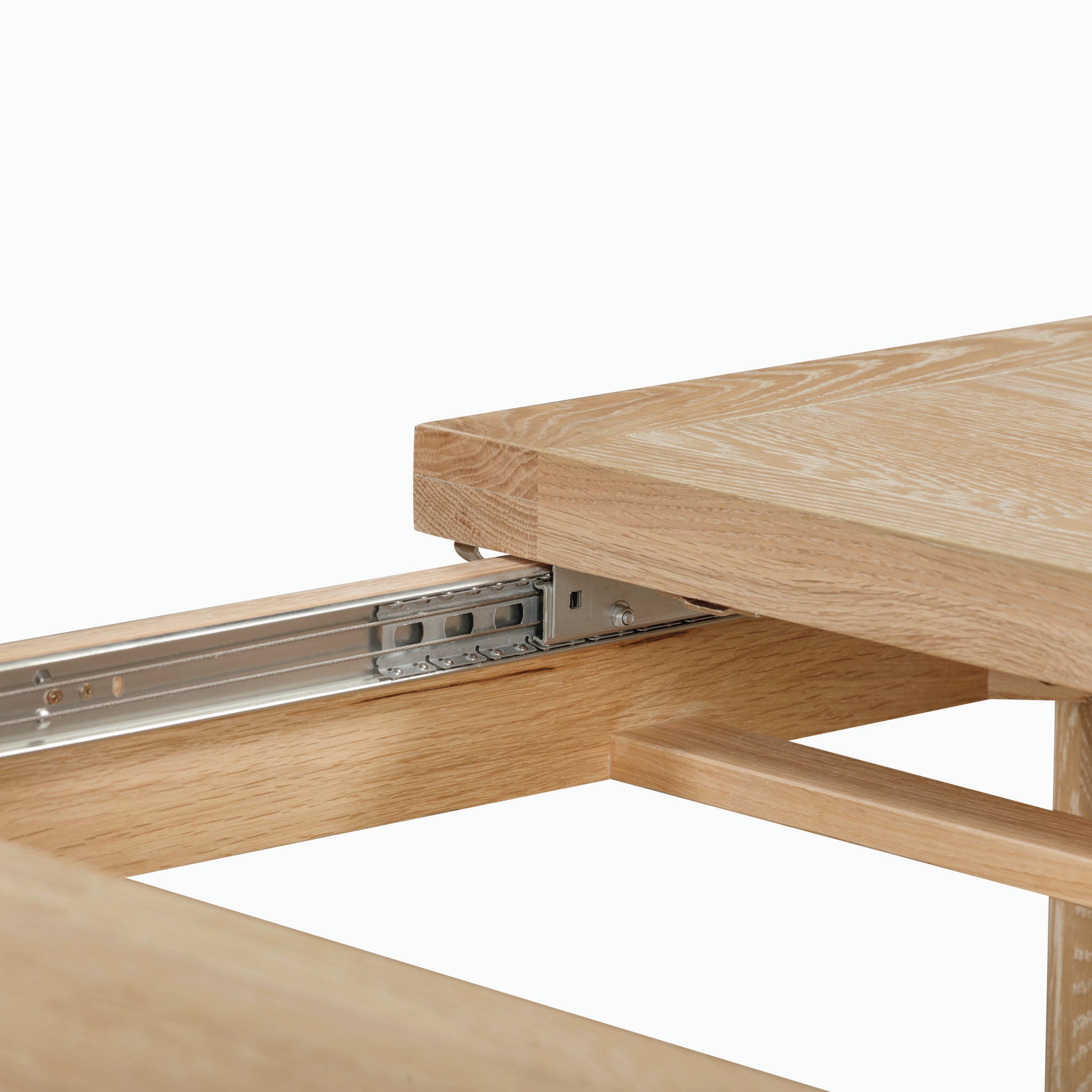 Close-up of the Burford 8 Seat Extending Dining Set with Regent Chairs in Natural Oak and Ivory, highlighting the wooden extendable table and its visible metal sliding mechanism.