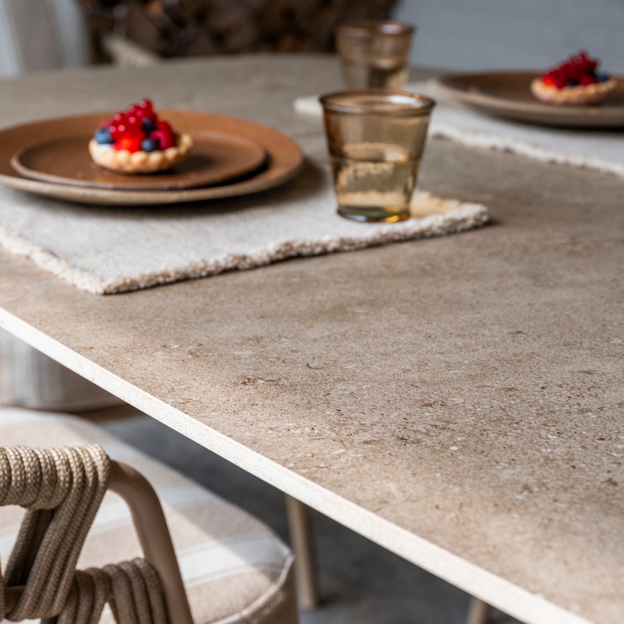 Close-up of the Madeira 6 Seat Curved Rectangular Dining Set in Striped Latte, elegantly styled with desserts, glasses, and plates on woven placemats—ideal for sophisticated outdoor dining.