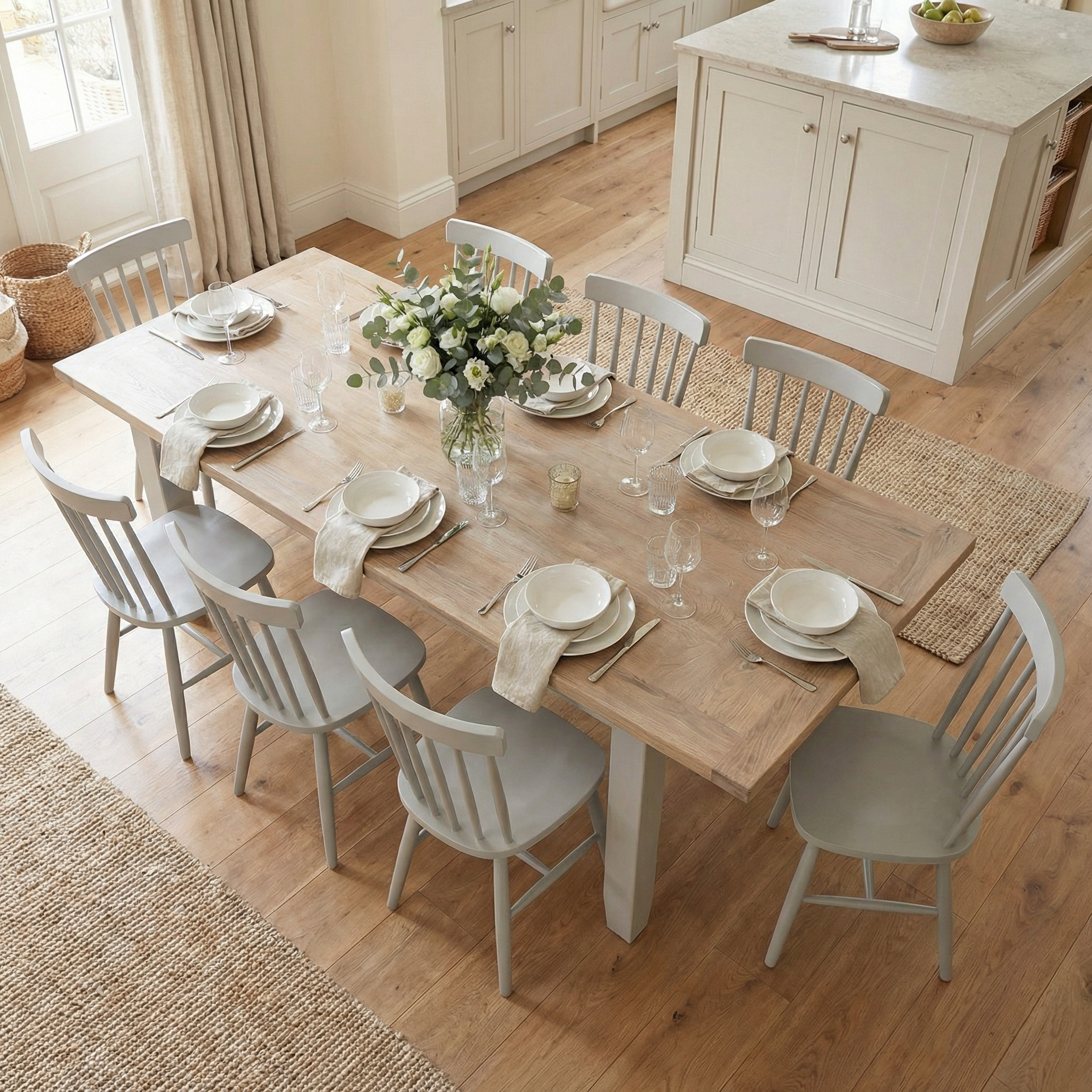 The Burford 8 Seat Extending Dining Set with Spindleback Dining Chair in Pebble Grey features a spacious table for eight, paired with classic spindleback chairs, perfect for bright kitchens and neutral dishware.