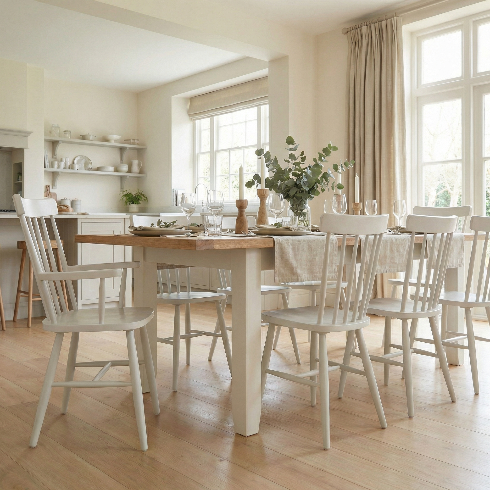 Bright dining room with the Burford 8 Seat Extending Dining Set and Spindleback Dining and Armchairs in Warm White, plus large windows for an inviting, neutral space.