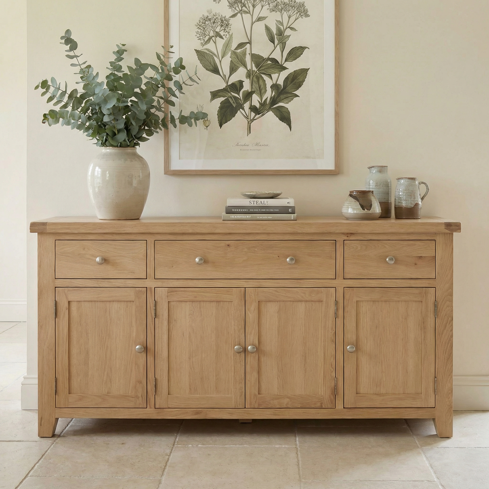 Natural oak Burford Large Sideboard with four doors, three drawers, and decorative accents including a vase with greenery and ceramics on top.