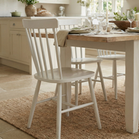 Burford Set of 2 Spindleback Dining Chairs in Warm White surround a set dining table, adding charm to a bright, cozy kitchen with neutral decor and plenty of natural light.