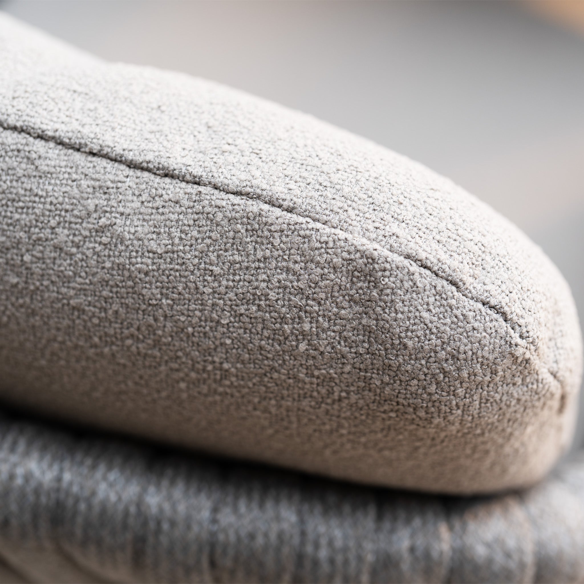 Close-up of a light gray textured fabric cushion with soft, natural lighting, highlighting the hand-woven rope detailing on the Capri 6 Seat Curved Rectangular Dining Set in Stone Grey.
