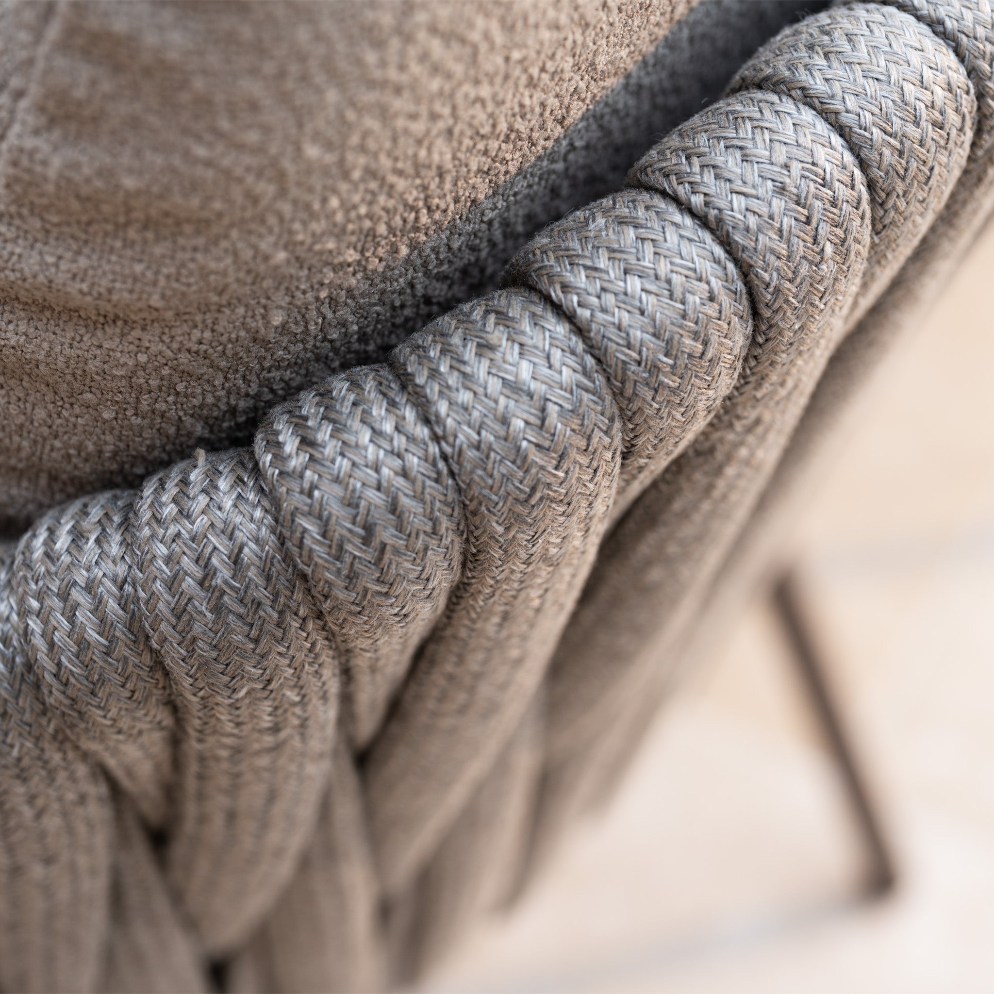 Close-up of the hand-woven rope detail on the back of a gray chair with fabric upholstery, part of the Capri 6 Seat Curved Rectangular Dining Set in Stone Grey—an elegant choice for outdoor dining.