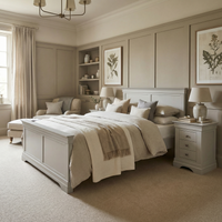 Elegant bedroom featuring the Chalbury 4ft 6" High End Double Bed Frame in pebble grey, cozy seating, chic lamps, and botanical artwork on the walls.