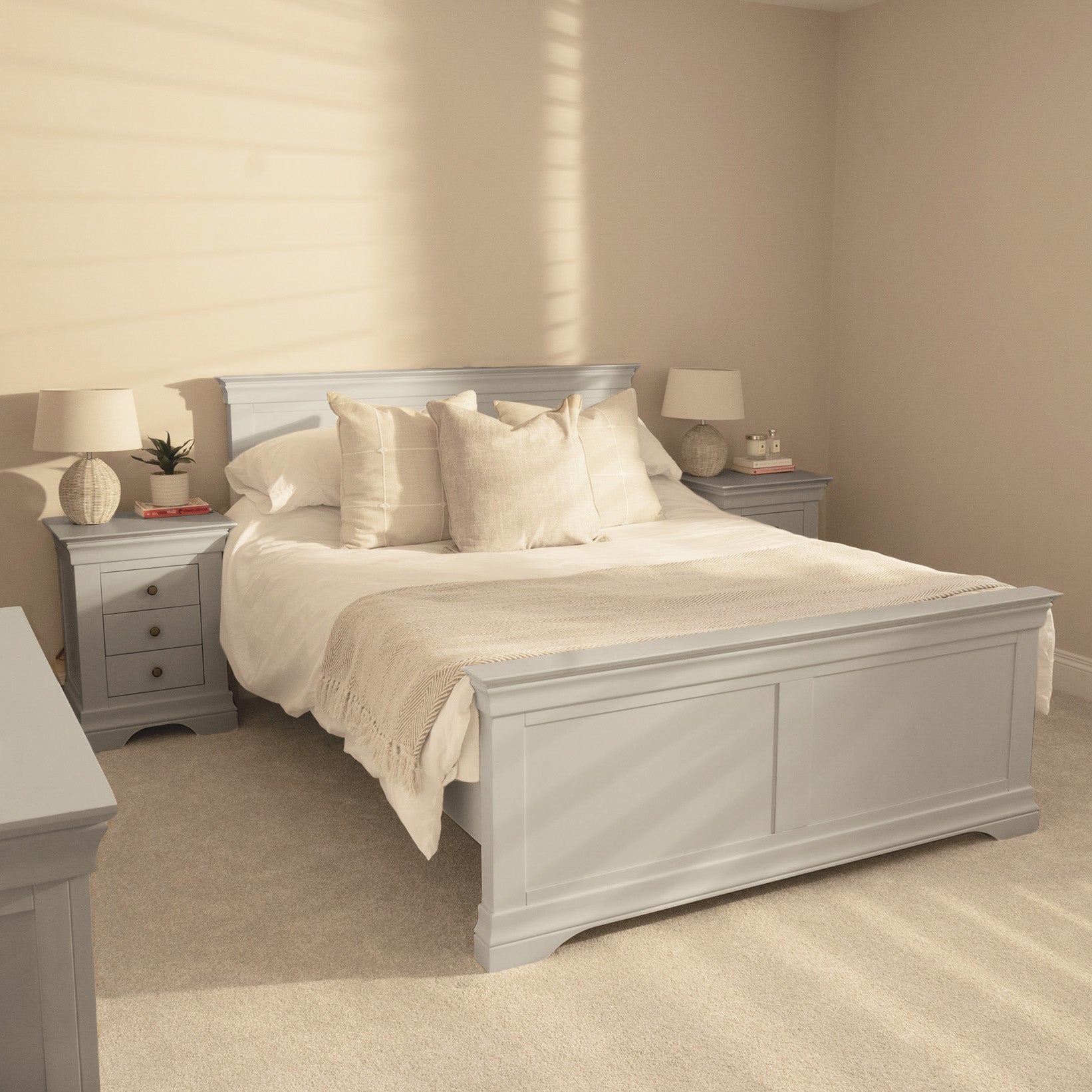 The Chalbury 5ft High-End Kingsize Bed Frame in Pebble Grey anchors this softly lit, neutral bedroom, paired with cream bedding and matching nightstands.