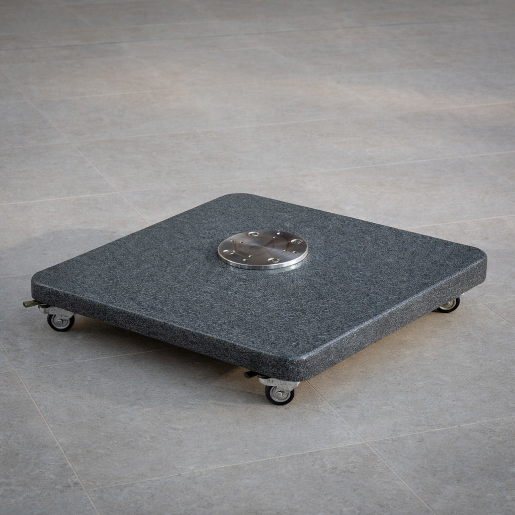 The Granite 120kg Cantilever Parasol Base With Wheels, topped with a metal plate, rests securely on a tiled floor.