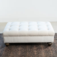 The Chesterfield Velvet Footstool in Cream features a rectangular tufted design with wooden legs—an elegant accent piece or ottoman for bright rooms.